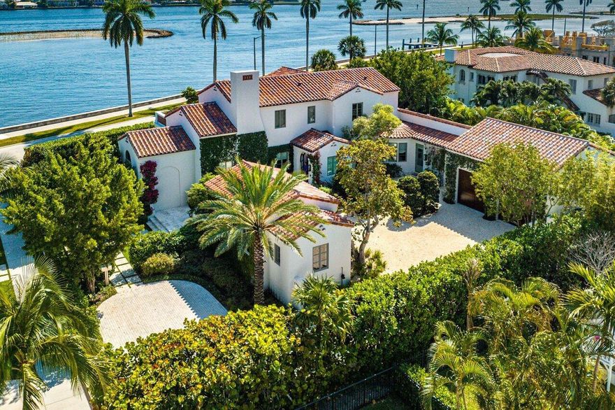 A romantic waterfront paradise. Pristine, extraordinarily detailed, 2020 construction with unimpeded water views from both the first and second floors. This home's condition is the definition of ''impeccable.'' 19,000 square foot lot beautifully landscaped by celebrated designer Keith Williams. A 52' lap pool sits off the electric screened terrace. Mexican roof tile and dappled waxed plaster walls are a nod to classic Palm Beach architecture within a clean contemporary envelope. Luxurious downstairs primary bedroom with long Intracoastal views. Two second floor bedrooms with full baths and an expansive upstairs terrace reached by stair or elevator all enjoy sweeping water views. Separate guest house can be used as a gym. 3 bay garage is fitted with lifts and can accommodate up to 5 cars