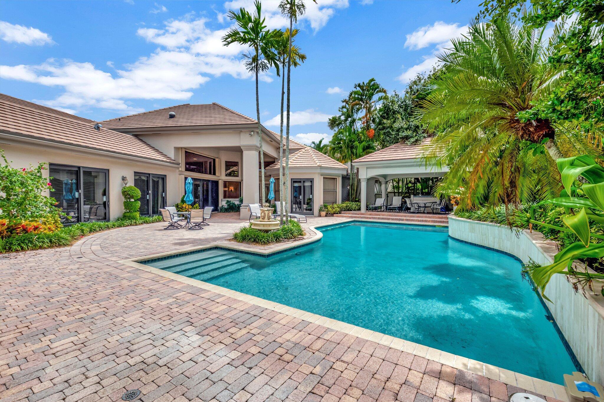 Welcome to this exquisite courtyard estate home located in the prestigious Village of Vintage Place within the Broken Sound Country Club. Nestled on a .35-acre corner lot, this stunning property spans over 4,200 square feet of luxurious living space. Featuring 4 spacious bedrooms, 4.5 beautifully appointed baths, and a private guest house, this home offers unparalleled comfort and style. The main house includes a recently added large den and office, perfect for work or relaxation. Step into your own private oasis with this stunning home, featuring a spacious courtyard that invites you to relax and entertain. The centerpiece is a sparkling heated pool, perfect for year-round enjoyment, surrounded by lush landscaping that enhances the tranquil atmosphere. A covered barbecue area completes
