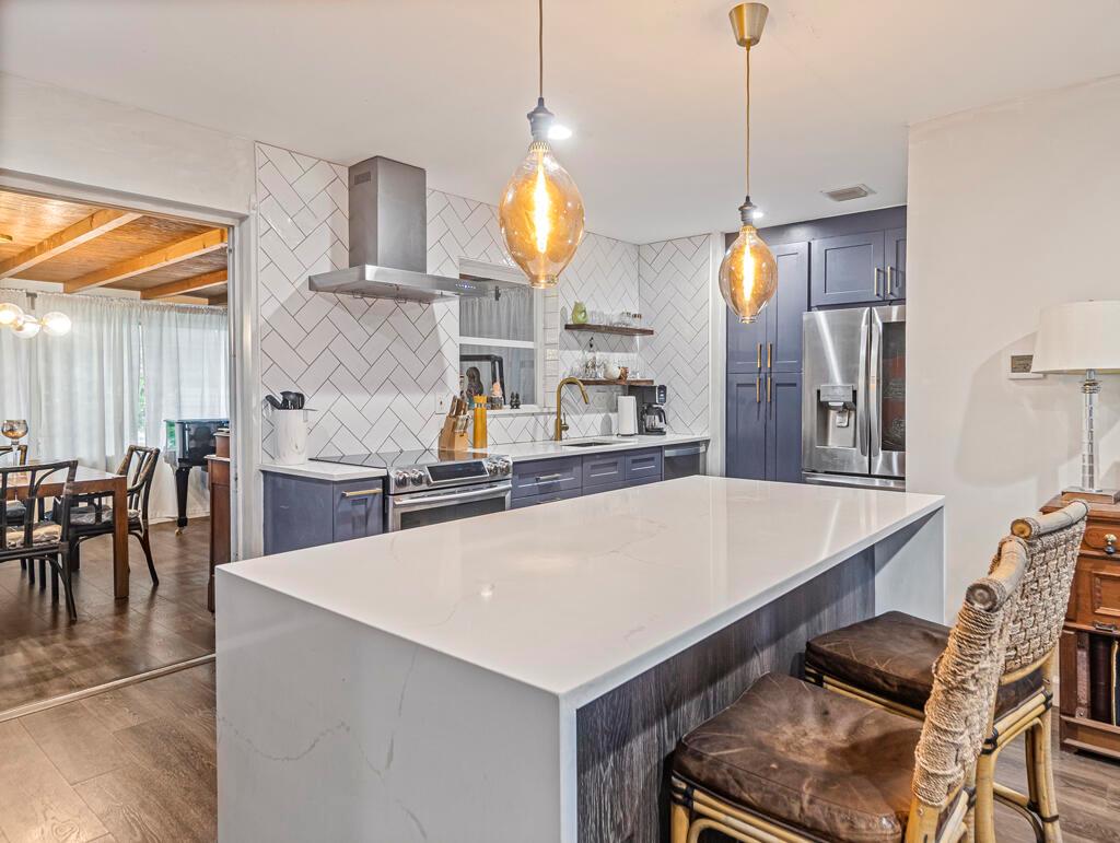 This beautifully updated Florida ranch - style home offers stylish indoor living and lush outdoor spaces in a quiet Lake Park neighborhood.The kitchen features a quartz waterfall-edge island, stainless steel appliances, and modern finishes throughout including new interior doors and hardware. Having recently insulated the Florida Room ,this space provides bonus living area, while a new central A/C system ensures year-round comfort.Step outside to a Tropical backyard oasis with a partially covered expansive patio, outdoor shower, and thriving garden full of mature tropical plants.The front yard is equally well maintained and includes a covered porch and circular driveway for convenience. A half bath is located off the garage area for flexibility. Large side yard offers room for RV or Boat.