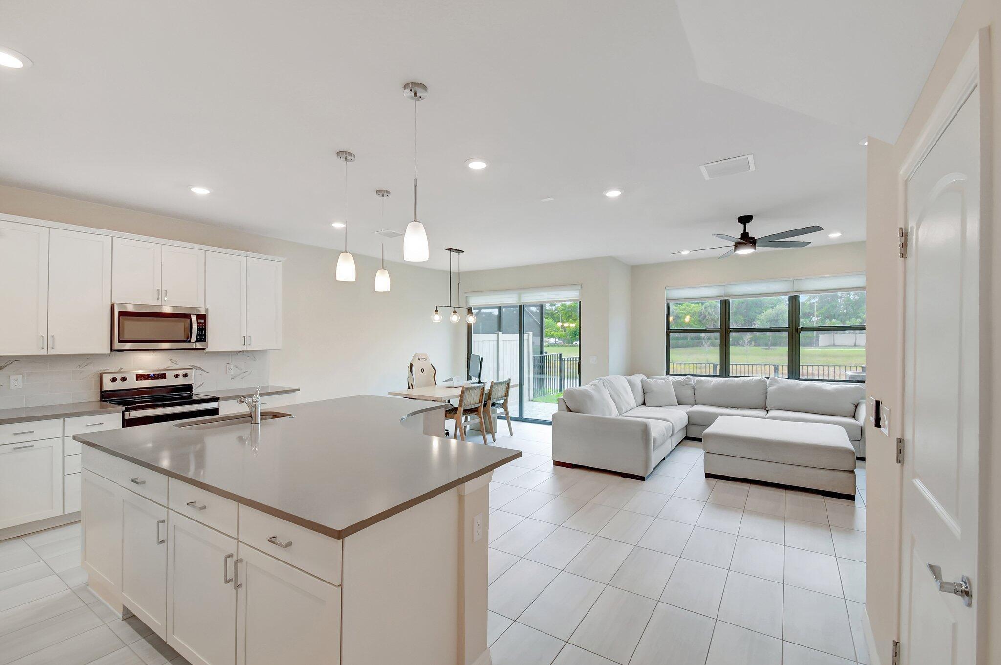 This stunning 3-bedroom, 2.5-bathroom townhome, in Oak Tree- just three years new, offers a bright and open floor plan with breathtaking lake views from the living room, dining room, kitchen, and primary bedroom. Step into a designer kitchen featuring elegant white cabinetry, an oversized island with premium Blanco quartz countertops, and stainless steel appliances--perfect for entertaining. The home showcases sleek ceramic tile flooring throughout the main living areas, adding a touch of sophistication. The spacious primary suite includes 2 walk-in closets and an upgraded en-suite bath with double sinks and a modern glass-enclosed shower. Additional highlights include a dedicated laundry room with a laundry tub and plenty of storage space. Located in a gated community, residents