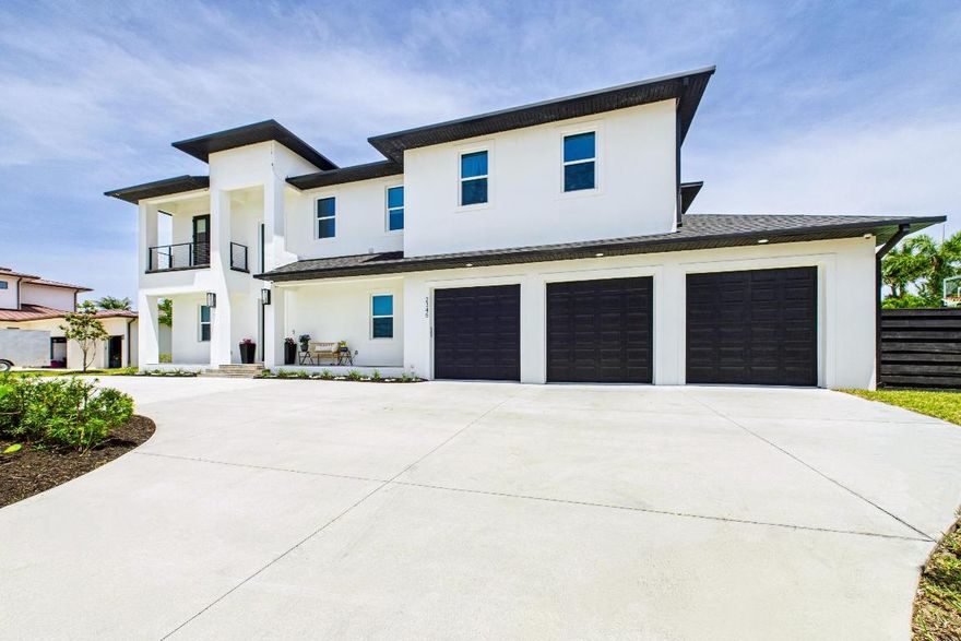 THIS 2022 contemporary is a STUNNER - she offers sky-high ceilings, marble tile floors, and a dramatic stacked stone fireplace in a sunlit great room.  Sliders open to a fenced backyard, covered lanai, and summer kitchen are perfect for indoor/outdoor entertaining.  LED lighting throughout.  The first-floor owner's suite is a serene retreat with dual walk-in closets, tray ceiling, stand-alone tub, quartz vanities, and a tiled shower with bench.  Upstairs, modern comfort, and coastal living combine beautifully in this exceptional home.