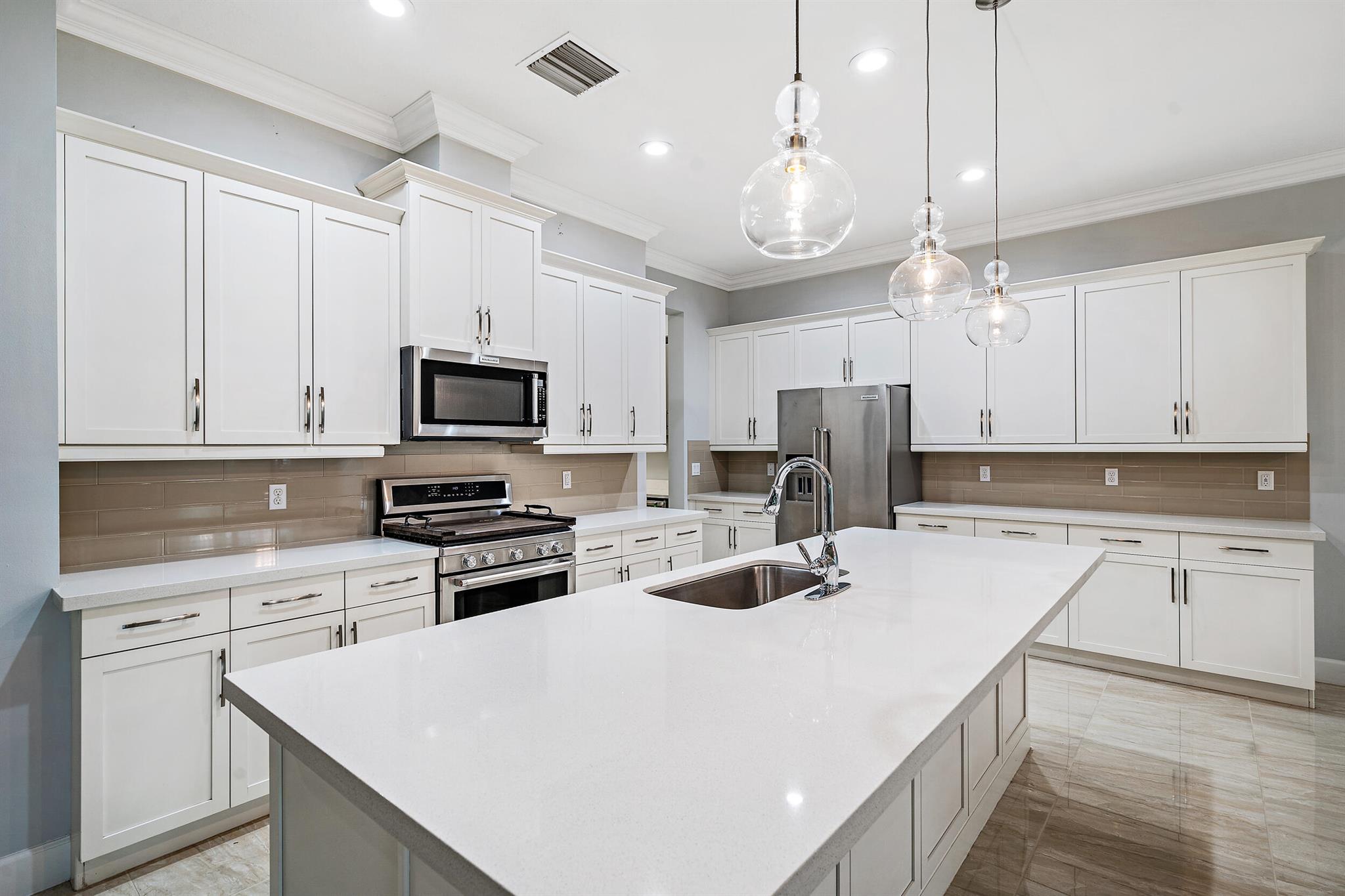 Rarely available, newer construction home (2018) in West Lake Worth's best kept secret community of Andalucia. This 5 bedroom, 4 bathroom home features a bright white modern kitchen with quartz counters, large island, KitchenAid appliances, two wine chillers, and large pantry. Backyard of the property is perfect for entertaining and/or relaxing under an ample sized covered screened-in patio overlooking a very private, beautifully manicured landscape. Home is equipped with impact windows and multicamera home security system. Be just a few doors away from the community pool and fitness center with the convenience of close proximity near the turnpike and zoned for ''A'' rated schools.