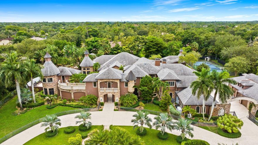 This exceptional estate, constructed by Terry Shore, is set on over 7 acres of fully fenced and gated grounds, offering a total of 22,000 sq. ft. of living space. The main residence encompasses 12,000 sq. ft., complemented by a 1,200 sq. ft. guest house with a full kitchen. Additional amenities include a separate two-story exercise facility featuring a sauna and steam bath, which may also serve as guest quarters, as well as a 9-car climate-controlled garage. The property further boasts a 10-seat movie theater, an English pub room with billiards, three fireplaces, and a built-in office with wainscoting. All windows and doors are equipped with impact protection, and the estate includes a full-house generator.Additional features comprise three laundry rooms and a Crestron lighting and home