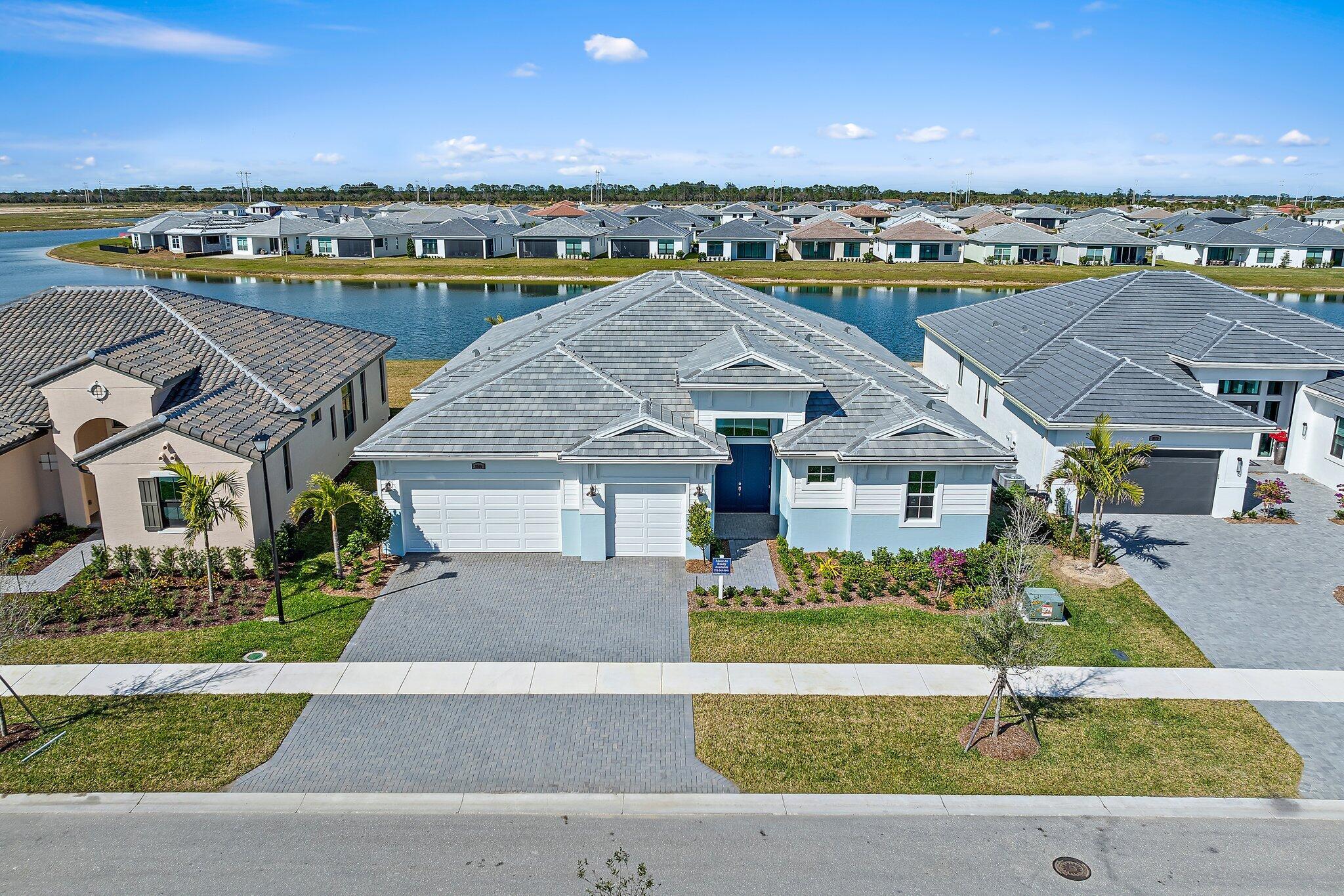 **NEW CONSTRUCTION** Move in Ready. This lakeside home features an east-facing exposure, providing beautiful views and natural light. It includes 3 Bedroom, a Flex, 3 Full and 1 Half Bathroom and 3-Car Garage. The Kitchen is equipped with a 30'' cooktop with a hood, cabinet crown molding, 42'' upgraded cabinets with a 4-drawer stack, Cambria quartz countertops, under-cabinet lighting, and a stainless steel single bowl undermount sink. Additional features include a full wrap-around wet bar, a frameless shower in the Owner's Bath, and an upgraded lighting package throughout. The Lanai has a 5' privacy wall and a Summer Kitchen. Tray ceilings enhance the home's elegance and spaciousness.