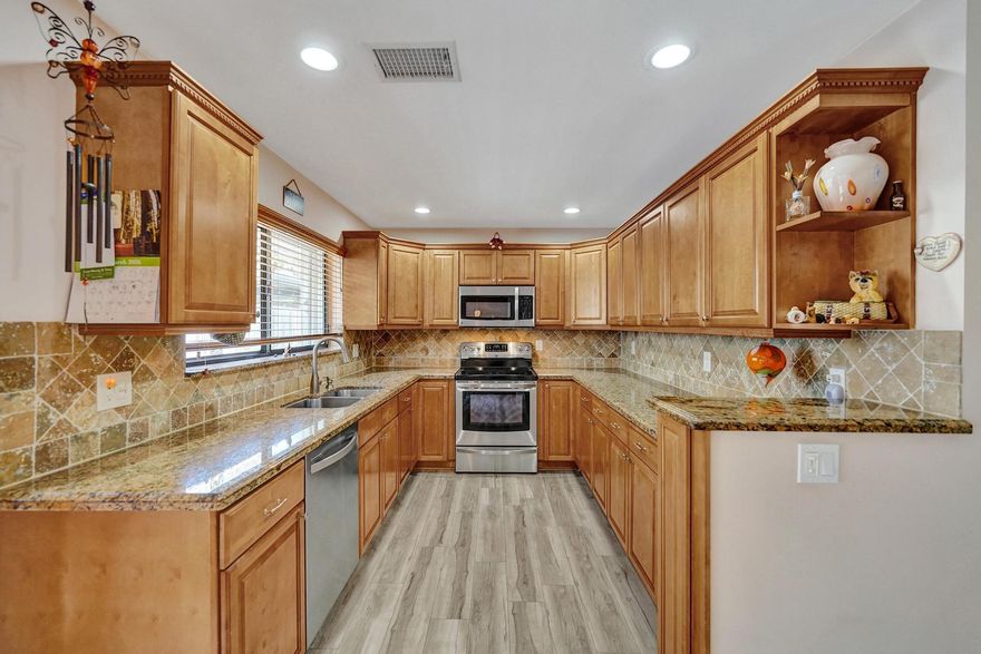 100% move-in ready in sought-after Cross Creek! Beautifully updated 3-bed, 2-bath waterfront home shines with vaulted ceilings, bright open living, true South Florida lifestyle. The kitchen features wood cabinets, granite counters, and stainless steel appliances. Updated baths include new vanities, new shower enclosure, spa-style primary cabana bath with jacuzzi tub. Plantation shutters. Enclosed patio creates the perfect Florida room/flexible living space. Low maintenance pavers at front entrance, driveway, and in fully fenced backyard ideal for relaxing or entertaining. Newer A/C, new water heater, LED lighting, modern flooring. Generator ready, full hurricane protection. 2-car garage. HOA covers lawn care, trees, sprinklers, lake, and walking path. Close to shopping, dining, highways!