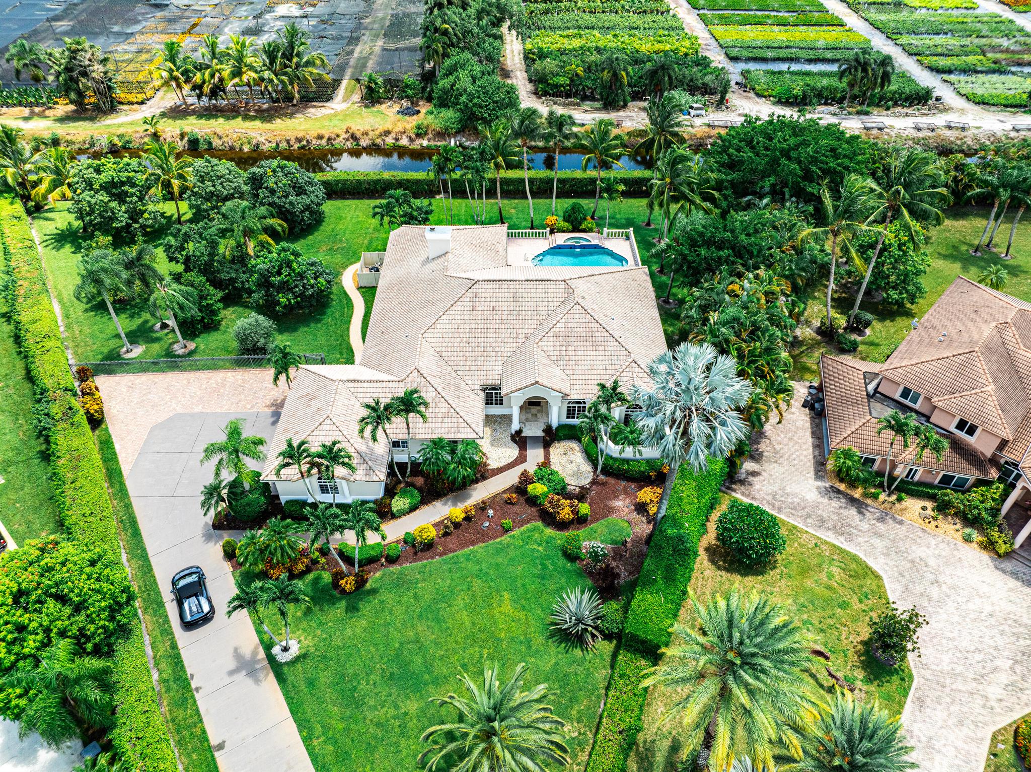 Experience the essence of luxury and resort-style living in this private one-acre estate nestled in the top cul-de-sac location, within the prestigious 24-hour manned gated community of Delray Lakes Estates in Delray Beach. Every detail of this magnificent residence displays elegance, from the custom design and unique architecture to the breathtaking wood and marble flooring and more. The heart of this home is a culinary masterpiece--a large gourmet chef's kitchen adorned with granite countertops and top-of-the-line Monogram appliances. Step outside into your own private oasis, where a spacious salt water pool/ spa deck allures, complemented by a covered patio featuring an outdoor kitchen and built-in BBQ--a perfect venue for entertaining guests or savoring beautiful outdoor dining.