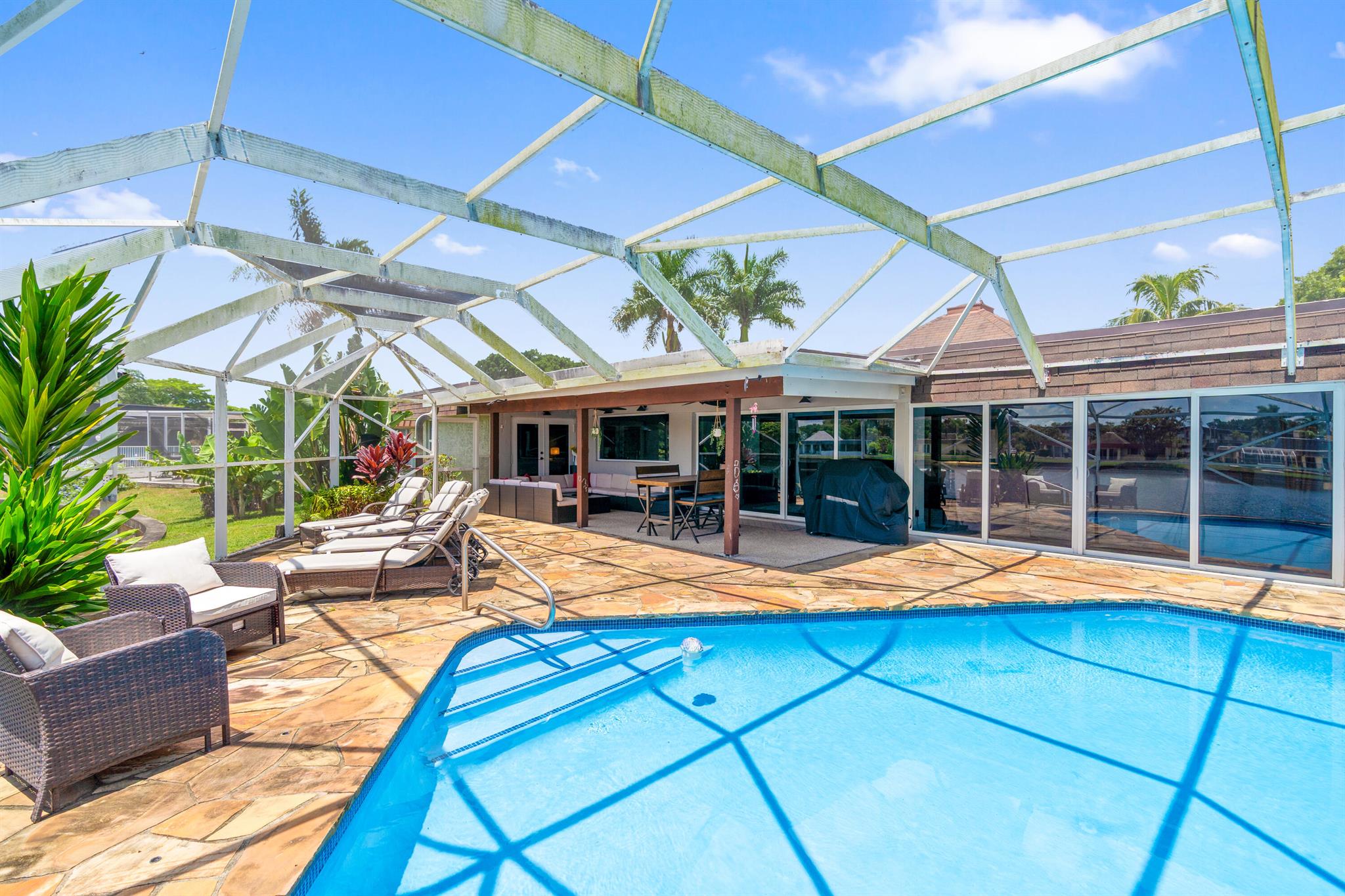 Remodeled to perfection with all the comfort and Luxury you can imagine. Besides beautiful Lake Views and a Private Pool with screened Patio, this Residence offers plenty of Space with 5 Bedrooms, 3 full Bathrooms and a large Volume Ceiling. Peace of Mind is garanteed by complete impact window protection. The house is powered and cooled by 45 solar panels. ''The Woodlands'' is the most sought after location in Tamarac and properties have sold for over 2 Million Dollars recently. The Clubhouse is being updated including Amenities which adds Value to this amazing Residence. This is a rare opportunity to aquire one of the largest Waterfront Pool Properties still available in this desirable Community. Must watch Walk Through Video !