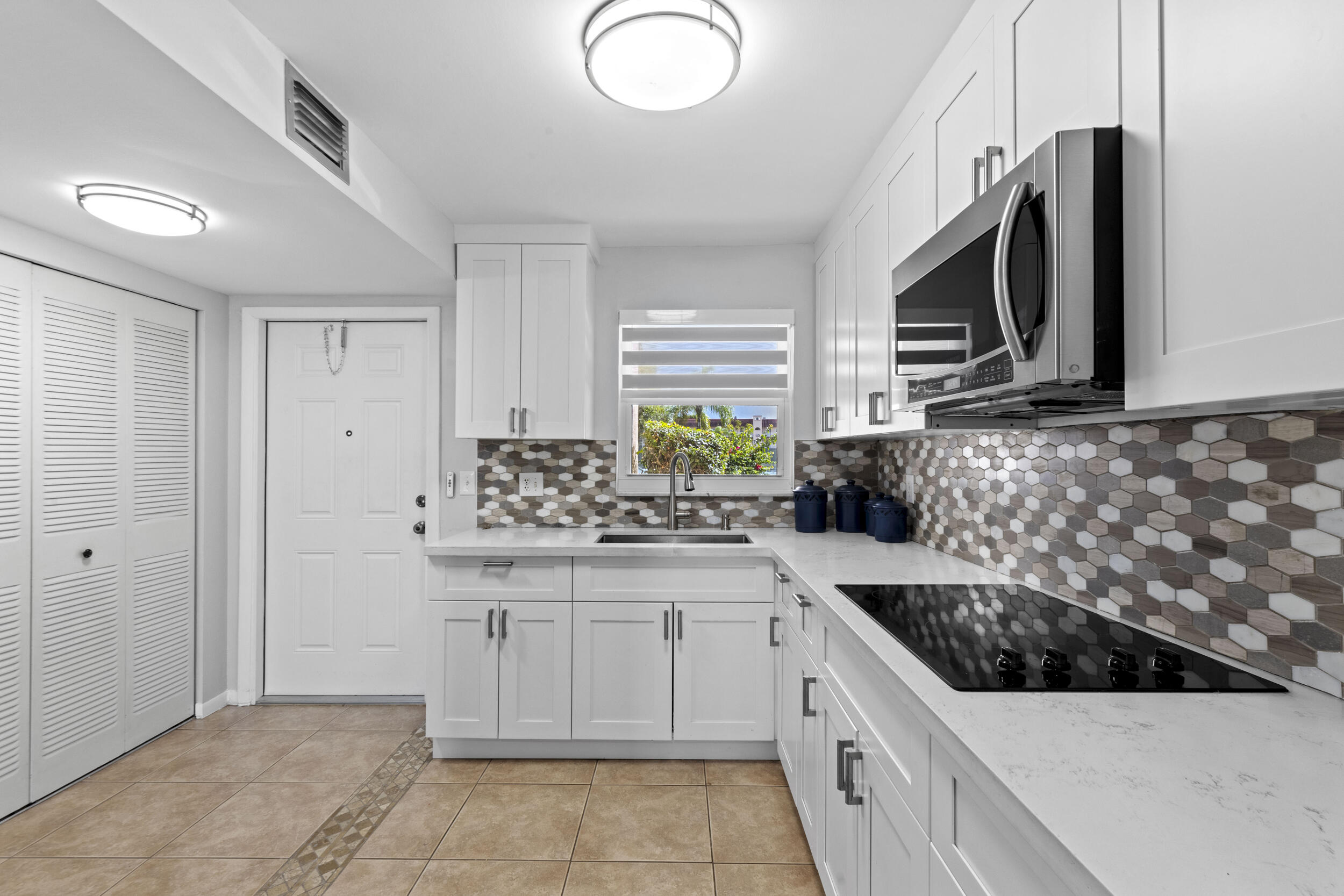 Over $50,000 in upgrades! Enjoy this RENOVATED OPEN CONCEPT , 1st FLOOR & CORNER condo with DOUBLE LAKE views and FULL IMPACT WINDOWS w/ premium & motorized blinds. This 2 bedroom, 2 bath has 2 large closets. The expanded kitchen has white shaker wood cabinets, S/S appliances and stunning white quartz countertops with room for a small eat in area. Relax on the SUNNY PATIO and take in the peaceful water views. Just 12 miles to the beach and near the Sawgrass Mall. Close distance to the satellite pool, tennis & pickleball courts. Parking #28 is in front of unit. Storage unit in 2nd floor. Plus another main clubhouse, theater, pool, gym, tennis, BBQ area, clubs, activities & more.