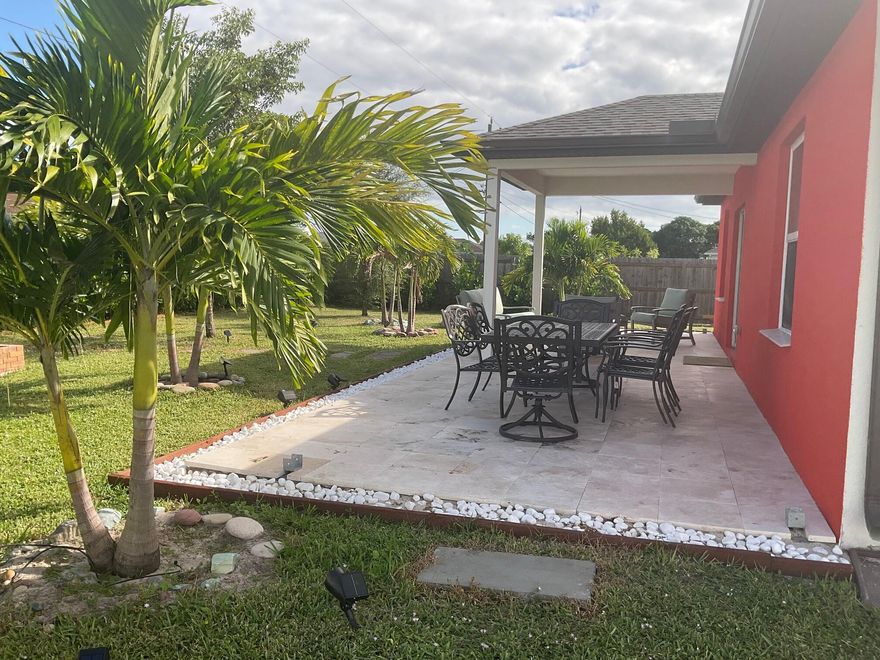 Don't miss out on one of the best values in South Florida! This luxurious, exceptionally maintained, practically NEW 4BR home total is 2324 Sqft, is available due to the owner's job relocation and showcases over $150,000 in recent upgrades. Enjoy a gourmet kitchen with granite countertops, stainless steel appliances, and a smart home system. Security system with cameras included. $55K solar panels reduce power bills to about $28/month. Outdoor oasis features a $30K new 456 sq. ft. Travertine patio and $28K in lush landscaping with mature palms, sprinkler, and irrigation. Peace of mind Impact windows, $10K new plantation shutters, $15K custom paint, new fence, shed, and new washer/dryer complete this move-in-ready gem.  With its premium features this home won't last long.