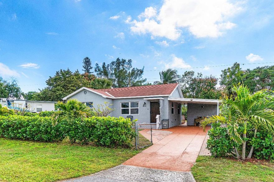 Immaculate 2-bedroom, 2-bath single-family home tucked within a quiet, established neighborhood, offering comfort, style, and convenience. Beautiful tile and parquet floors flow through bright, welcoming spaces, with an open kitchen and dining area ideal for cooking, gathering, and everyday living. Features include high-impact storm windows, a separate utility/laundry room, storage room, and covered carport. The newer tiled bathrooms feel fresh and inviting. Step outside to an expansive fenced yard with fruit trees, plenty of green space, and room for a pool, patio, or garden. Close to shopping, public transportation, and St. Mary's Hospital — peaceful, practical, and truly a must-see. Ready to move right in and enjoy!