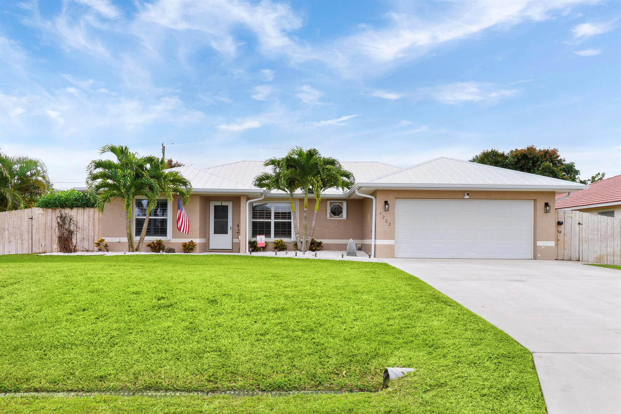 Featuring move in ready 3 bedroom 2 bathroom 2 car garage home located in Port St Lucie, situated on a beautifully landscaped half acre lot with 1/4 surrounded by well maintained eureka palms perfect for privacy, plenty of room for your RV, boat storage or simply for entertaining space. 2022 metal roof, 2021 AC, 2019 water heater, 2022 full house water softener & filtration system. Walk into high vaulted ceilings, open floorplan, spacious eat-in kitchen. Newly installed plantation shutters. Large master bedroom with walk-in closet. Fully renovated 2022 master bath. Large screened/covered patio.