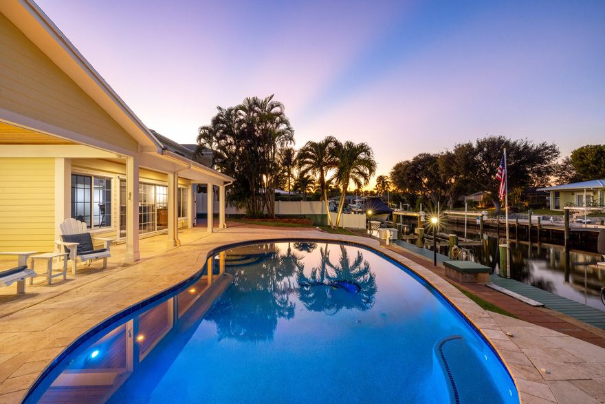 Set along a deep-water canal on a quiet cul-de-sac within one of North Palm Beach's most established, family-friendly streets, this waterfront residence reflects a calm, considered approach to coastal living one that values both refinement and function. With 80 feet of seawall, a decked-over dock, and two boat lifts rated at 16,000 and 12,000 pounds, the property offers seamless access to open water and a lifestyle shaped by time spent outdoors. Inside, light-filled interiors unfold through an open layout that maintains a constant visual connection to the water. The 2024 kitchen is intentionally curated, finished with quartzite countertops, a gas cooktop, wall oven, and new stainless-steel appliances, balancing everyday usability with elegance. The oversized primary suite is set apart as a private retreat, offering dual walk-in closets and a spa-style bath with a two-person Jacuzzi tub, double shower, and dual vanities. Two additional bedrooms with hardwood floors provide flexibility for guests or home office use. A generous family room, anchored by a gas fireplace and a built-in wet bar with beverage refrigerator and quartzite countertops, opens through a full three-panel slider to an oversized, vaulted-ceiling covered patio and expansive paver pool terrace. Outdoors, a custom 2014 pool equipped with an air chiller overlooks the deep-water canal, creating a seamless indoor-outdoor setting well suited for entertaining. Recent updates include a new roof (2024), gas water heater (2025), plantation shutters, crown molding, and solid-core doors, resulting in an enduring expression of modern coastal living.