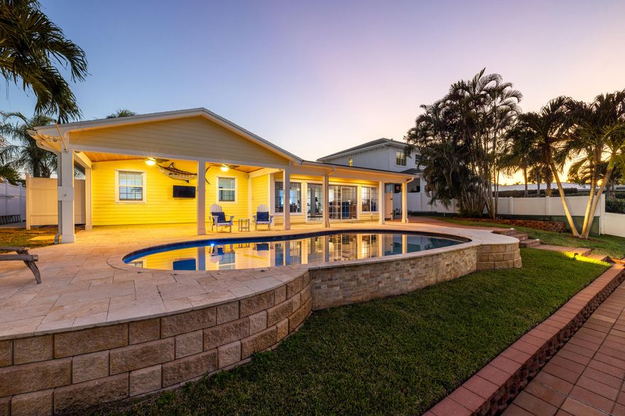 Set along a deep-water canal on a quiet cul-de-sac within one of North Palm Beach's most established, family-friendly streets, this waterfront residence reflects a calm, considered approach to coastal living one that values both refinement and function. With 80 feet of seawall, a decked-over dock, and two boat lifts rated at 16,000 and 12,000 pounds, the property offers seamless access to open water and a lifestyle shaped by time spent outdoors. Inside, light-filled interiors unfold through an open layout that maintains a constant visual connection to the water. The 2024 kitchen is intentionally curated, finished with quartzite countertops, a gas cooktop, wall oven, and new stainless-steel appliances, balancing everyday usability with elegance. The oversized primary suite is set apart as a private retreat, offering dual walk-in closets and a spa-style bath with a two-person Jacuzzi tub, double shower, and dual vanities. Two additional bedrooms with hardwood floors provide flexibility for guests or home office use. A generous family room, anchored by a gas fireplace and a built-in wet bar with beverage refrigerator and quartzite countertops, opens through a full three-panel slider to an oversized, vaulted-ceiling covered patio and expansive paver pool terrace. Outdoors, a custom 2014 pool equipped with an air chiller overlooks the deep-water canal, creating a seamless indoor-outdoor setting well suited for entertaining. Recent updates include a new roof (2024), gas water heater (2025), plantation shutters, crown molding, and solid-core doors, resulting in an enduring expression of modern coastal living.