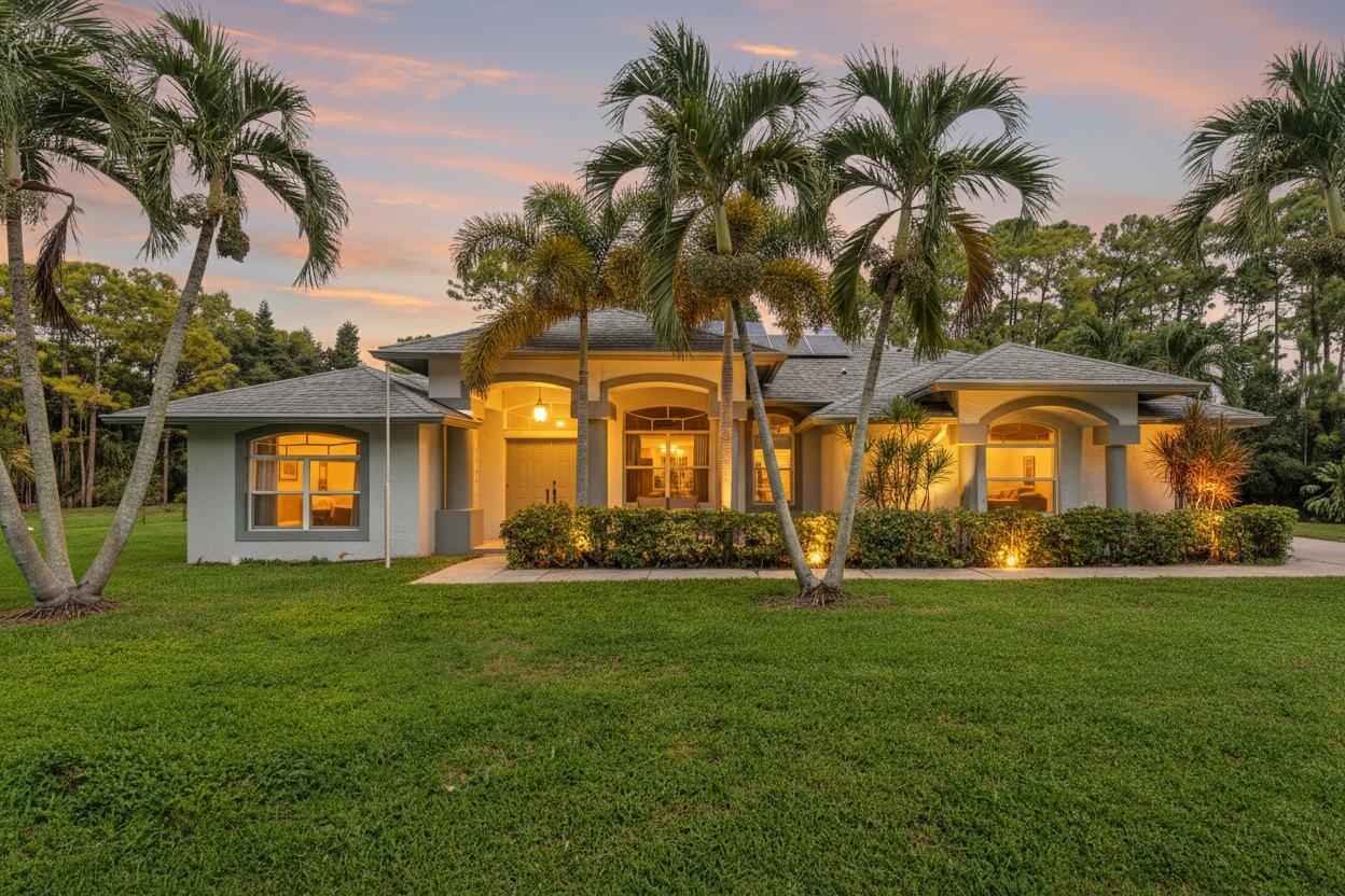 Escape to your own private, sustainable sanctuary in Loxahatchee, where the dream of true Florida country living meets modern, energy-efficient comfort. Tucked away on a tranquil, no-traffic street, this enchanting 3-bedroom, 3-bath home sits on a sprawling 1.31-acre lot with absolutely no HOA, granting you unmatched freedom to park your RVs, boats, or trailers. Embrace the wide-open sky and your incredible outdoor oasis, featuring a large screen-enclosed pool with a sundeck for endless Florida enjoyment, and a huge covered patio with outdoor fans perfect for dining al fresco or relaxing in the shade. Step inside to discover 2,335 sq ft of spacious, thoughtfully updated living, including a versatile flex room complete with a wet bar and full bath--ideal for a private office, media lounge,