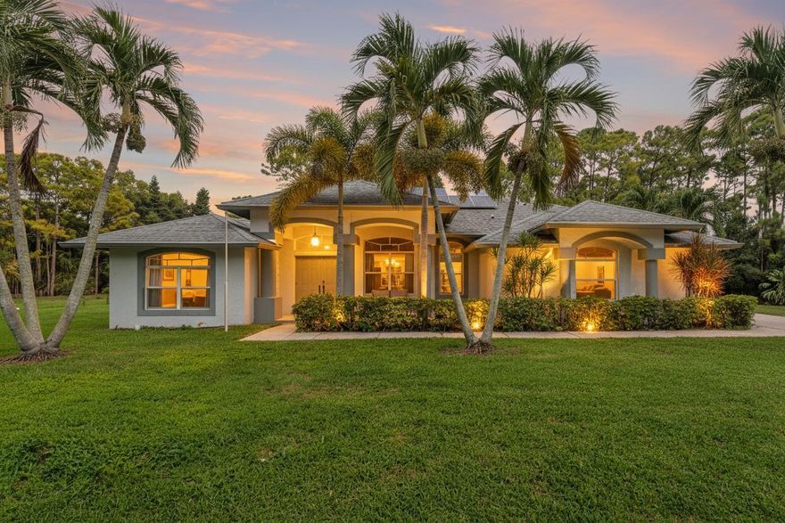 Escape to your own private, sustainable sanctuary in Loxahatchee, where the dream of true Florida country living meets modern, energy-efficient comfort. Tucked away on a tranquil, no-traffic street, this enchanting 3-bedroom, 3-bath home sits on a sprawling 1.31-acre lot with absolutely no HOA, granting you unmatched freedom to park your RVs, boats, or trailers. Embrace the wide-open sky and your incredible outdoor oasis, featuring a large screen-enclosed pool with a sundeck for endless Florida enjoyment, and a huge covered patio with outdoor fans perfect for dining al fresco or relaxing in the shade. Step inside to discover 2,335 sq ft of spacious, thoughtfully updated living, including a versatile flex room complete with a wet bar and full bath--ideal for a private office, media lounge,
