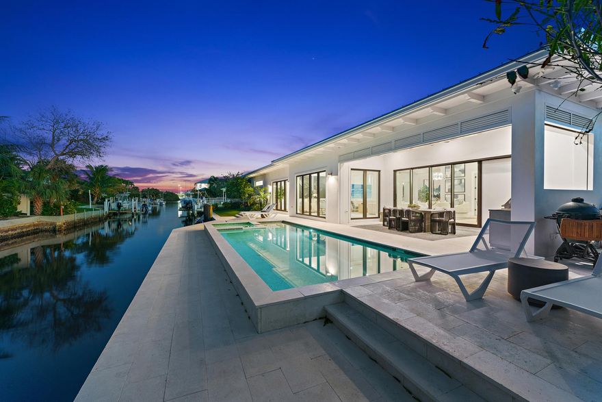 Newly constructed in 2022, the coastal contemporary waterfront lifestyle awaits in this stunning one-story, four bedroom, four-and-a-half-bathroom home featuring 100 feet of ocean-access waterfrontage with no fixed bridges, in the heart of Palm Beach Gardens! Beyond the stately foyer with 16' ceilings, natural light washes through this perfectly appointed open concept with no detail overlooked. Entertain in the great room, celebrate in the dining area, or gather in the eat-in area off the stunning chef's kitchen featuring beautiful white cabinetry finished with Quartz counters, custom stainless-steel appliances, center island with bar seating, and hidden walk-in pantry with a wine cooler and custom shelving. Retreat to the spacious primary suite with