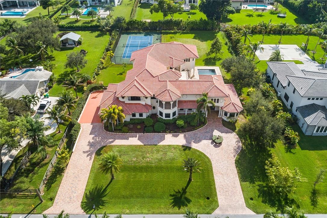 Welcome to this custom Plantation Acres Estate! The sprawling property features: 6 bedrooms, 6.5 bathrooms, 2 offices, an oversized game room & a studio art room away from the day to day activity. The luxurious primary suite offers his/her vanities, steam shower & onyx counters set amidst marble finishes. You will find marble and wood floors throughout the home, soaring 20ft ceilings, gourmet kitchen with a gas stove, 500-bottle temperature controlled wine room, butler’s pantry & hurricane impact windows & doors. The outdoor space is designed to enjoy South Florida weather with the courtyard overlooking the pool, balconies facing the lighted tennis courts & a private hurricane-proof guest house. Enjoy peace of mind with an emergency generator ensuring comfort and security in any weather.