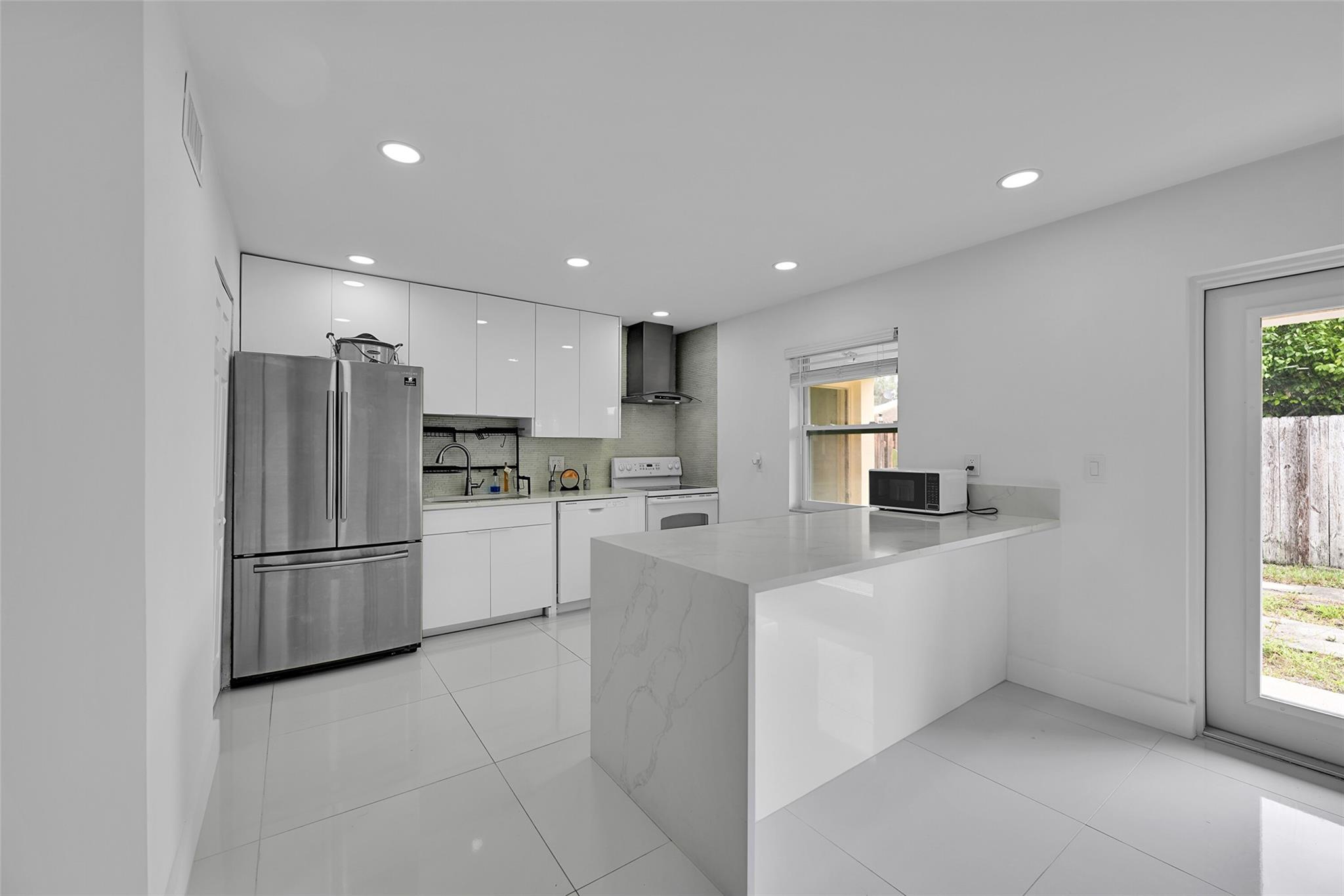 Welcome to this stunning corner unit villa featuring all impact windows and doors.
Inside, you will be stunned to see all the upgrades. Porcelain tile floors, recessed lighting, and a beautifully remodeled kitchen with quartz countertops, sleek handle-less cabinetry, and a walk-in pantry. The whole property was just painted. A full-size washer and dryer, a brand-new water heater, and a 2016 A/C .
Dimmer lighting throughout adds an elegant touch.
Step outside to your private fenced backyard—perfect for entertaining or relaxing. The property offers two dedicated front parking spaces along with ample guest parking. FHA and VA financing allowed! Don’t miss your chance—this gem will sell fast!