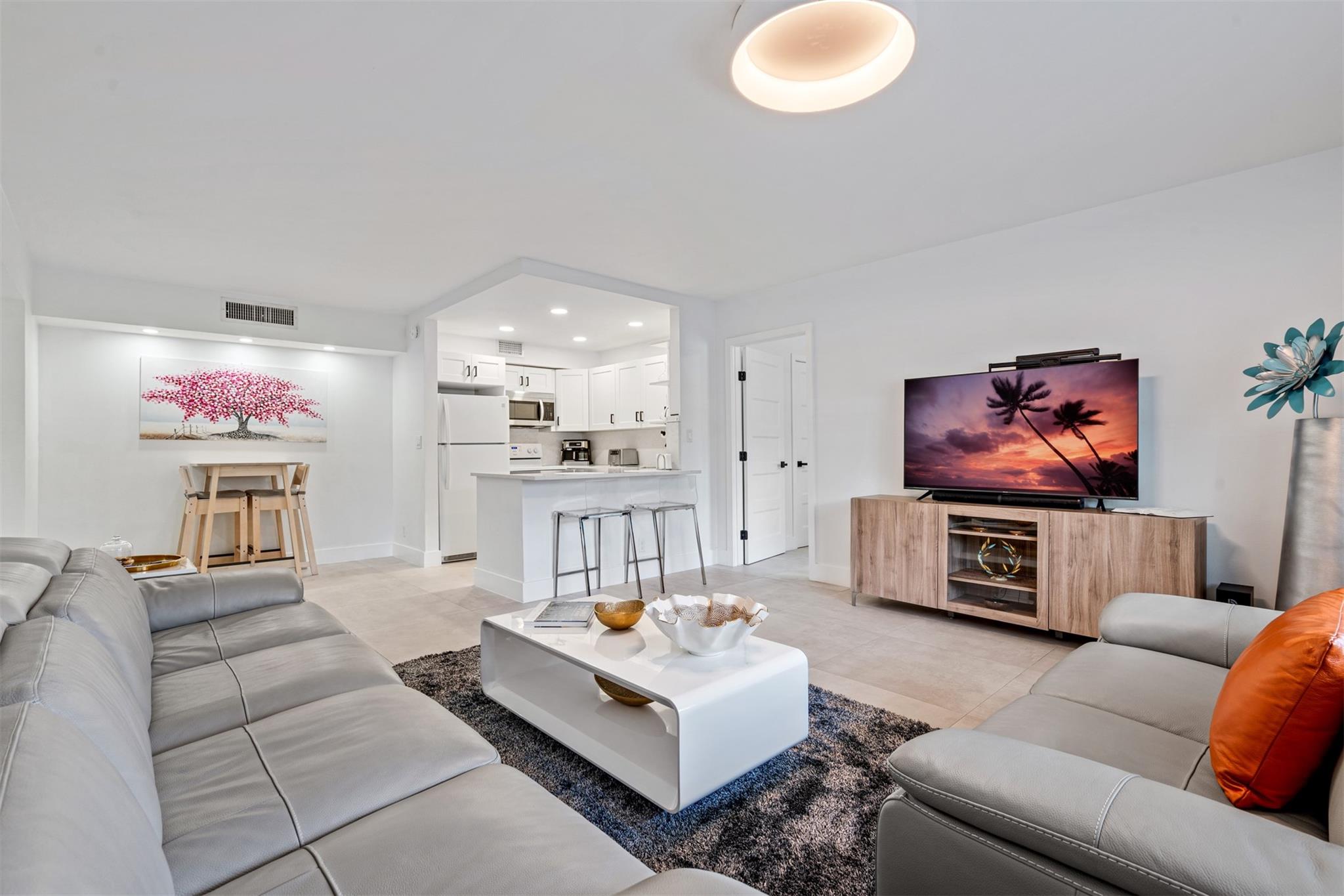 This beautifully renovated 2-bedroom, 2-bathroom corner unit offers a bright and airy open floor plan that feels both spacious and inviting. The kitchen is a modern chef’s delight, featuring crisp white cabinets complemented by stunning Quartz countertops. The tiled floors throughout the unit enhance its elegance and provide a clean look. The master bedroom includes a generous walk-in closet, providing ample storage space for your belongings. Impact windows fill the entire unit with abundant natural light, creating a warm and welcoming atmosphere. For added convenience, the unit comes equipped with a washer and dryer. Located less than 10 minutes from the Deerfield Beach Pier and The Cove Waterfront, this property is also near major highways, restaurants, airport, and shopping centers.