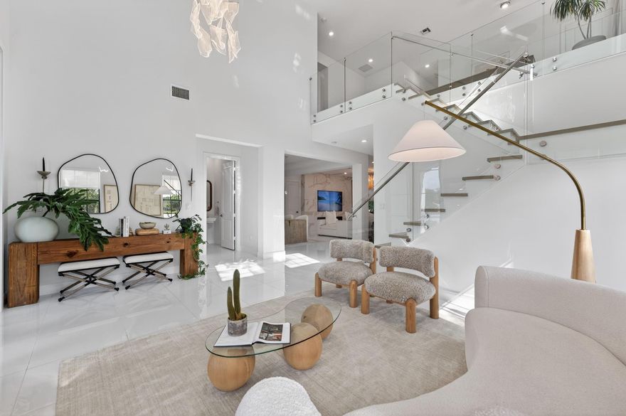 This sophisticated 5-bedroom, 5.5-bath residence combines exceptional design with premium finishes on one of the community's most private lots, with the asking price including $300,000 in designer furniture or available unfurnished. Showcasing over $200,000 in custom upgrades. Highlights include grand white porcelain tiles, white oak staircase with glass railings, designer quartz entertainment wall with fireplace, spa-inspired primary suite with freestanding tub, full cabana bath, multiple walk-in closets, upstairs loft, and exquisite chandeliers and custom drapery. This turnkey luxury home offers exceptional craftsmanship and immediate occupancy.