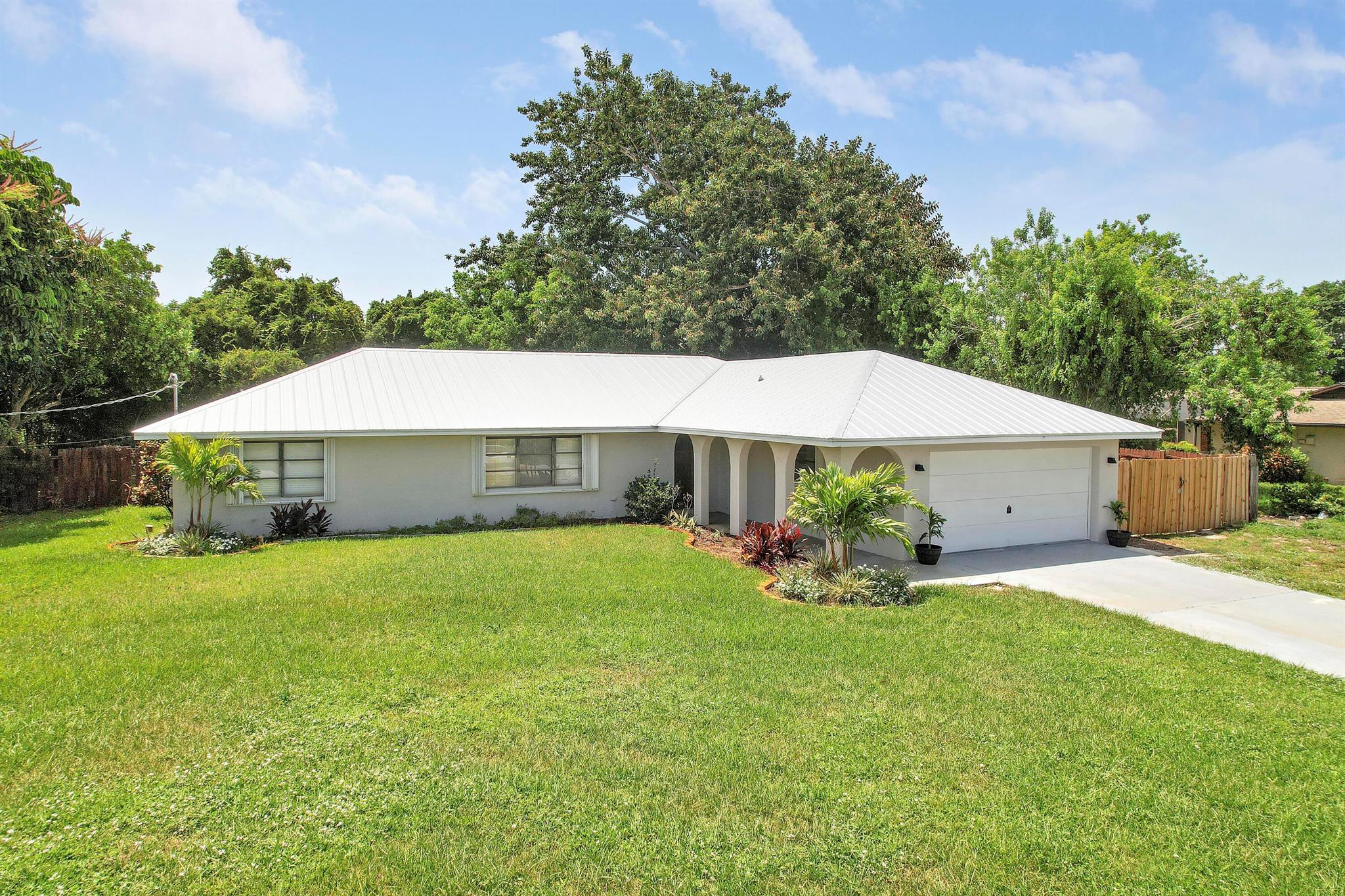 Nestled in the vibrant community of Port Saint Lucie. This charming 3-bedroom, 2-bathroom split bedroom home sits on just under a Half Acre lot. The interior boasts fresh, open spaces ideal for family living or entertaining. The heart of the home is the updated kitchen, featuring sleek quartz countertops paired with soft close cabinets. New Roof installed in 2022 along with an updated master bathroom a brand new water heater and new vinyl flooring throughout. Enjoy the flexibility to bring your RV, boat, or pets with zero HOA rules.