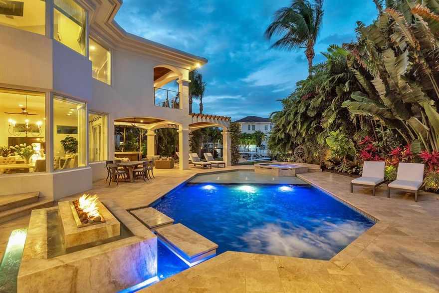 Are you seeking a lavishly luxe home with an outdoor poolside oasis, intoxicating Intracoastal views, and an elegant 1,100 sq ft primary suite? Idyllically nestled on an oversized corner lot, this 4BR/4.5BA, 4,710 sq ft executive residence offers unparalleled beauty with Mediterranean architecture, lush tropical landscaping, and a grand double door entrance. The wood flooring flows throughout the house; soaring ceilings, double height windows, an expansive great room, and a gourmet kitchen featuring premium appliances, new quartz counter-tops, center island with a prep sink and walk-in pantry. Masterfully designed for modern entertaining, the private backyard includes a redesigned heated swimming pool/spa, sprawling patios, luscious greenery, dockage, new pergola, prep island with sink and