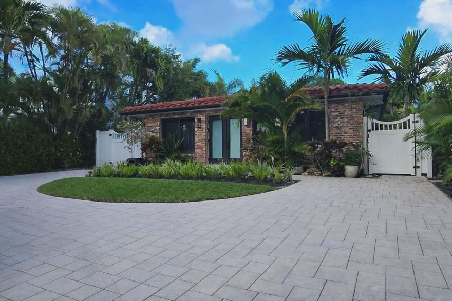 Presenting an extraordinary opportunity to own a home on one of Florida's most exclusive island enclaves.  Nestled nearly half a mile into prestigious Hypoluxo Island, you arrive to a circular driveway framed by lush tropical landscaping. An immediate sense of privacy and elegance welcomes you.  Inside, the residence showcases a seamless blend of sophistication and modern design.  The main home features 2 bedrooms and 1.5 bathrooms, thoughtfully designed for both everyday living and elevated entertaining. Distinguishing this property is the private, fully appointed guest studio suite—complete with its own separate entrance.  Outdoors holds a newly constructed pool with a sun shelf that anchors this redesigned backyard. This perfect outdoor living space is both tranquil and sophisticated. Residents of Hypoluxo Island enjoy close proximity to pristine beaches, world-class dining & clubs, and the unparalleled prestige that makes this island so desirable. This is more than a residence—it's a statement of island elegance and elevated living.