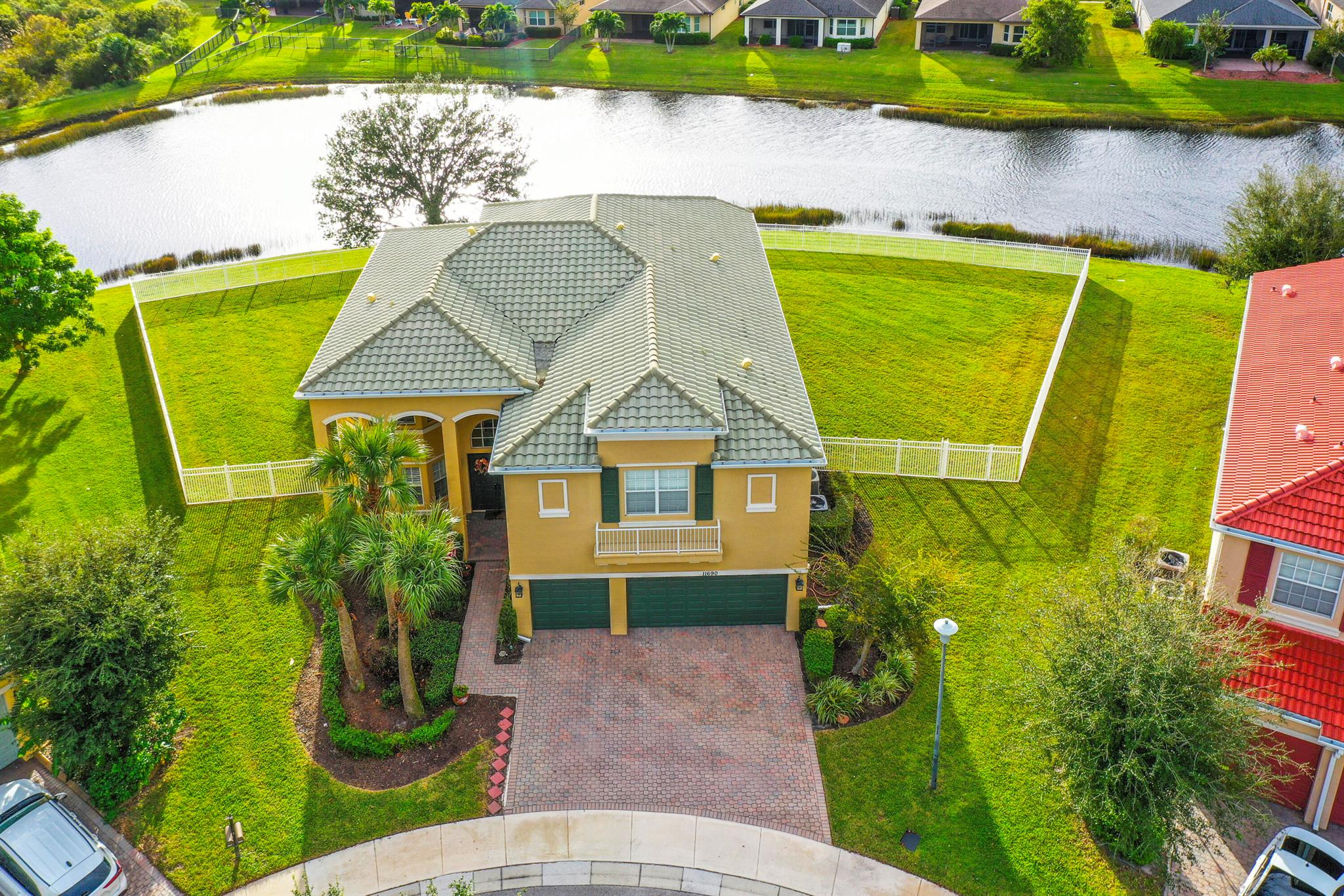 Step into elegance and space with this magnificent 5-bedroom, 4-bath, 3-car garage lakefront estate, perfectly situated on an oversized cul-de-sac lot in TownPark community. The grand double-door entry and soaring two-story foyer with a dramatic spiral staircase set the tone for sophistication and comfort. This home features hurricane impact windows & doors and a concrete block 2nd floor for peace of mind. Chef's kitchen with white cabinetry, granite counters, stainless steel appliances, double ovens, center island with prep sink, and a walk-in pantry. First-floor bedroom and full bath are perfect for in-laws, guests, or a home office. retreat to the expansive master suite complete with a private lounge area, ideal for a nursery, office, or reading nook. French doors open to a private..