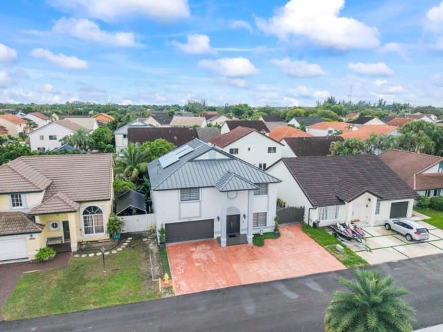 Motivated seller! Spacious 5BR/3 full BA home with 2-car garage plus 5-car driveway. Backyard oasis features a pergola, synthetic grass, board wall with generator cover, and a semi-ground pool to cool off, secured by fencing on cement base. Home upgrades include new metal roof with solar panels, impact front door, accordion shutters, LED lighting, and exterior security cameras. Remodeled kitchen with stainless steel appliances, 3 full modern bathrooms, tile flooring on first floor, laminate upstairs, organized garage with side closets, and independent laundry room with cabinets. Community offers tennis courts, pool, and playground. A true move-in ready home blending comfort, style, and modern upgrades.