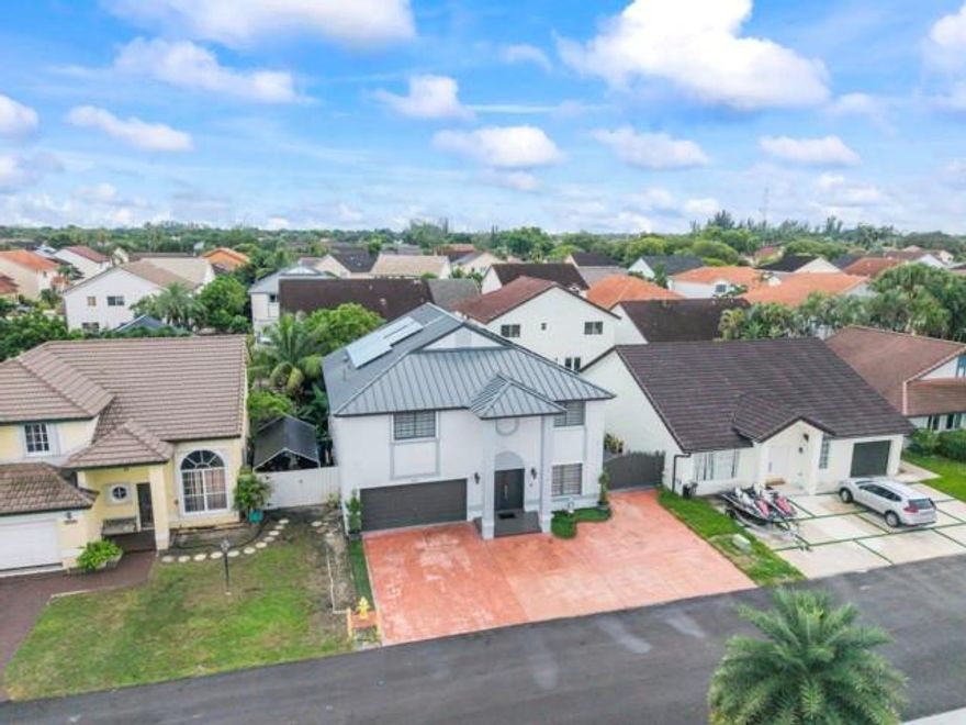 Motivated seller! Spacious 5BR/3 full BA home with 2-car garage plus 5-car driveway. Backyard oasis features a pergola, synthetic grass, board wall with generator cover, and a semi-ground pool to cool off, secured by fencing on cement base. Home upgrades include new metal roof with solar panels, impact front door, accordion shutters, LED lighting, and exterior security cameras. Remodeled kitchen with stainless steel appliances, 3 full modern bathrooms, tile flooring on first floor, laminate upstairs, organized garage with side closets, and independent laundry room with cabinets. Community offers tennis courts, pool, and playground. A true move-in ready home blending comfort, style, and modern upgrades.