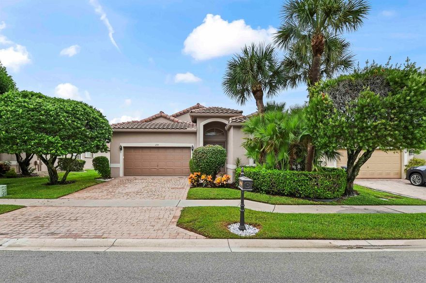 Welcome to this Mediterranean-style home, perfectly situated in the desirable 55+  community of the Cascades in Boynton Beach. The original owner residence offers striking curb appeal, featuring a tile roof, a paver driveway, and lush, tropical landscaping. Step through the elegant etched-glass double entry doors into a grand foyer defined by polished wood-look flooring, architectural archways, and decorative niches. The spacious main living areas are ideal for entertaining, boasting formal dining and sitting rooms, with an elegant flow and built in Bose sound system. One of the communities model homes, details include a sophisticated built-in aquarium and custom display shelving that add to the home's distinctive charm.