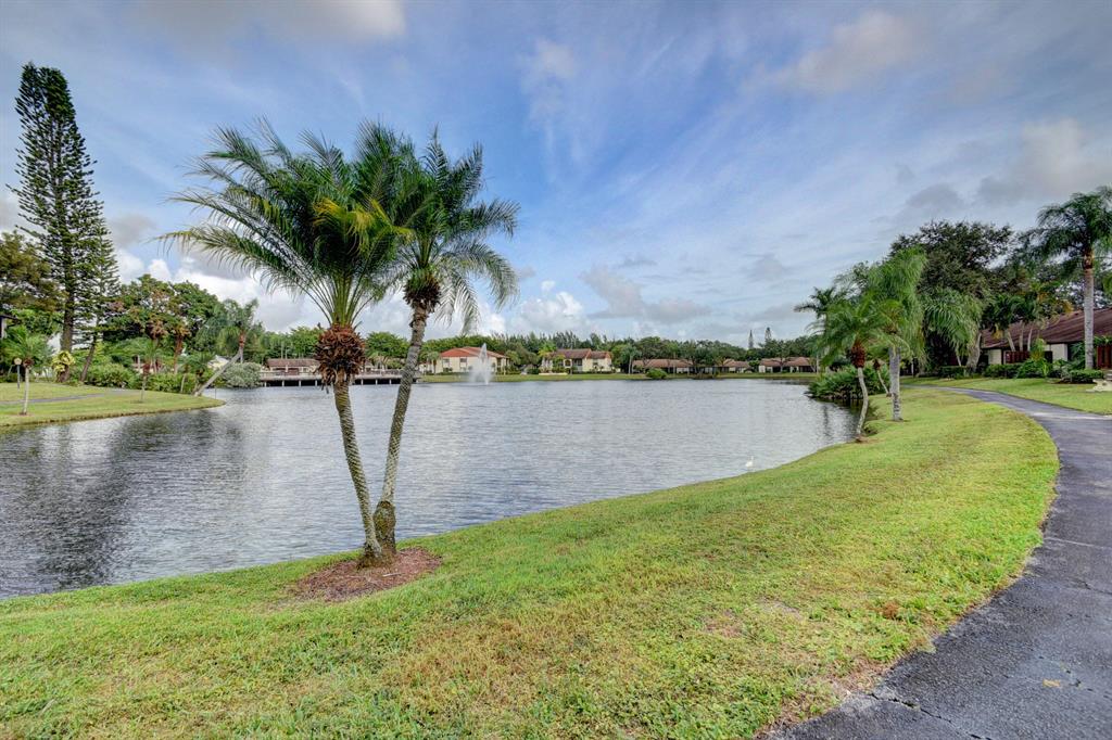 Enjoy Florida living in this RARELY AVAILABLE, 1st FLOOR WATERFRONT condo!Beautifully maintained 2 bedroom/2 bath 1st floor unit has open and spacious floor plan, tons of natural light, with over 1,100 SF of living area. Inviting entryway and screened patio boasts tile floor and large storage closet, with tranquil views of the wide lake and fountain. Lovely ceramic tile throughout the main living areas and kitchen with designer lighting, chair rail, molding, and custom shelves that allow for an added touch of class to the cozy dining area. Convenient open pass through to the updated kitchen equipped with Brand new sparkling Quartz counter tops, newer GE stainless steel appliances, corner stainless steel sink with updated faucet, and an abundance of cabinets.