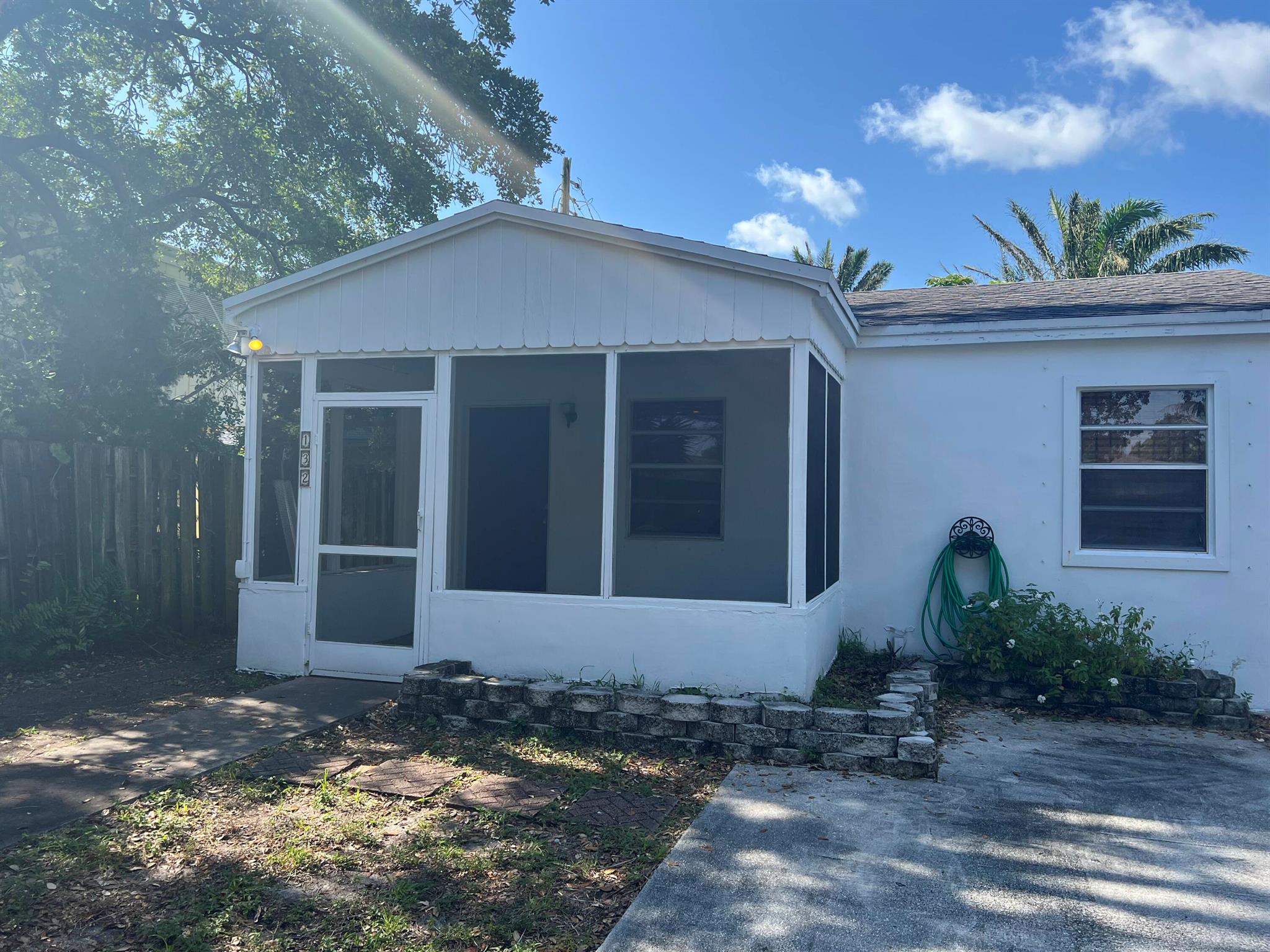 Welcome to this two-bedroom, one-bathroom unit located in a charming neighborhood just a five-minute drive from the beach. The property is less than thirty minutes from West Palm Beach, conveniently situated near restaurants, shopping, and a local park. The unit includes one parking space, and washer and dryer facilities are shared with Unit 1 and Unit 2.