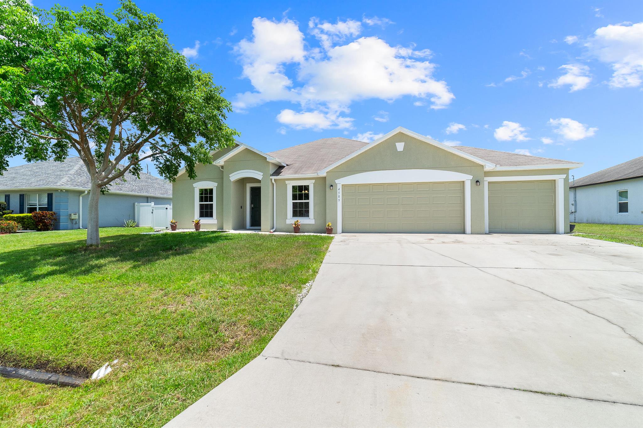 Welcome home to this immaculate 3 bedroom 2 bathroom opportunity located in the highly sought after NO HOA area of central Port St. Lucie. 3 CAR GARAGE with tons room for storage, parking or toys! As soon as you enter, you immediately notice the soaring vaulted ceilings and abundant natural light. The home provides LVP flooring throughout and has a split bedroom floor plan for added privacy. The kitchen boasts modern white cabinetry, stainless steel appliances and a large breakfast bar extending out into the family room, perfect for entertaining. The primary suite features high ceilings, tons of closet storage and large en suite bath. The secondary bedrooms are of ample size as well with the secondary bath centrally located.