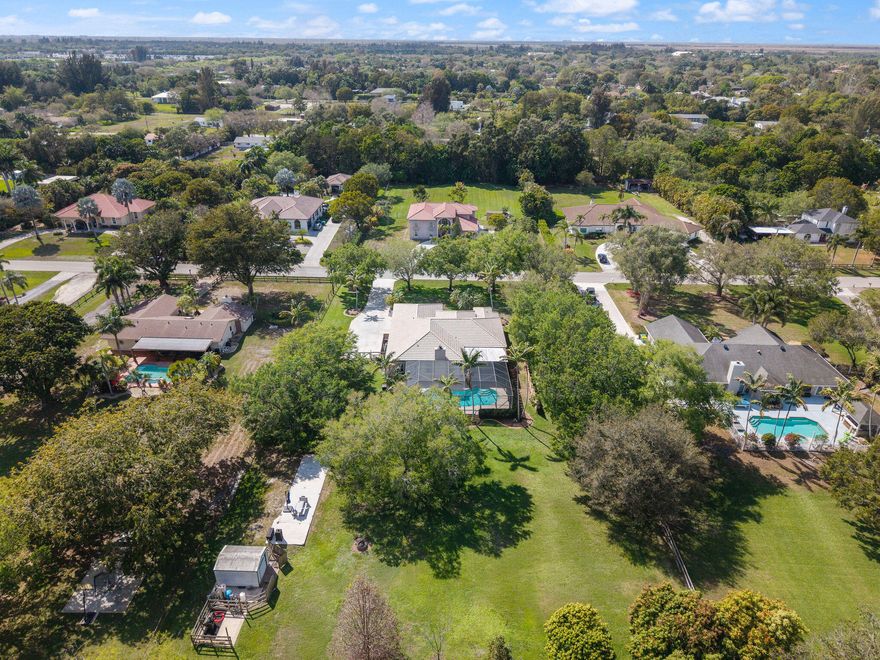 Located in the heart of prestigious Southwest Ranches this beautifully maintained home sits on a private 1 acre lot surrounded by mature oak trees at the entrance and throughout the property creating a peaceful park like setting rarely found in South FL. The residence features 4 bedrooms and 3 full baths with a spacious layout and a 3 car garage. The kitchen offers quality appliances including double ovens that are approximately 5 years old ideal for cooking and entertaining. Enjoy a charming wood burning fireplace and an expansive screened patio overlooking the heated pool and lush backyard. The property is fully fenced with a full sprinkler system and no rear neighbors as it backs up to a protected conservation area offering exceptional privacy nature views and a unique SWR lifestyle.