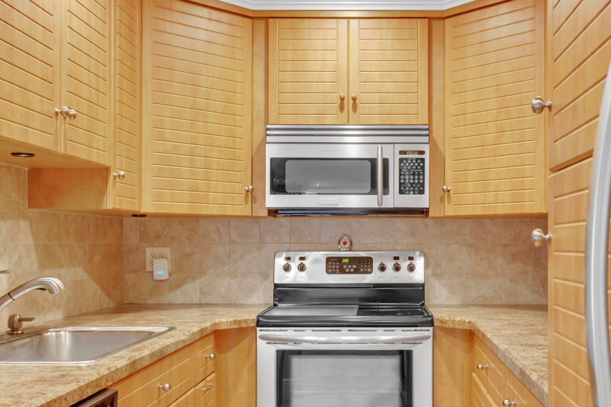 This fully renovated and reconfigured 2-bedroom, 2-bath villa features diagonal tile flooring, crown molding, and knock-down ceilings throughout. The redesigned kitchen offers ample cabinetry, stainless steel appliances, a snack bar, and custom wood cabinets with pullout drawers. The patio has been converted into additional living space. Both bathrooms have been renovated, with the primary bath fully redesigned. The unit provides generous storage and closet space. All windows are impact-resistant and finished with plantation shutters. A new roof was installed in 2025. Quarterly fees include exterior building insurance and maintenance, roof, water, sewer, and basic cable. Limetree is a 55+, pet-friendly community offering a range of activities for an active lifestyle, including bingo, card  games, crafts, parties, classes, and trips. The clubhouse features a library, sauna, exercise room, billiards, shuffleboard, and Bocce tournaments. Residents can choose from three heated swimming pools and have access to tennis and pickleball courts. The location is convenient, close to the beach, shopping, dining, theaters, I-95, the Turnpike, and airports.