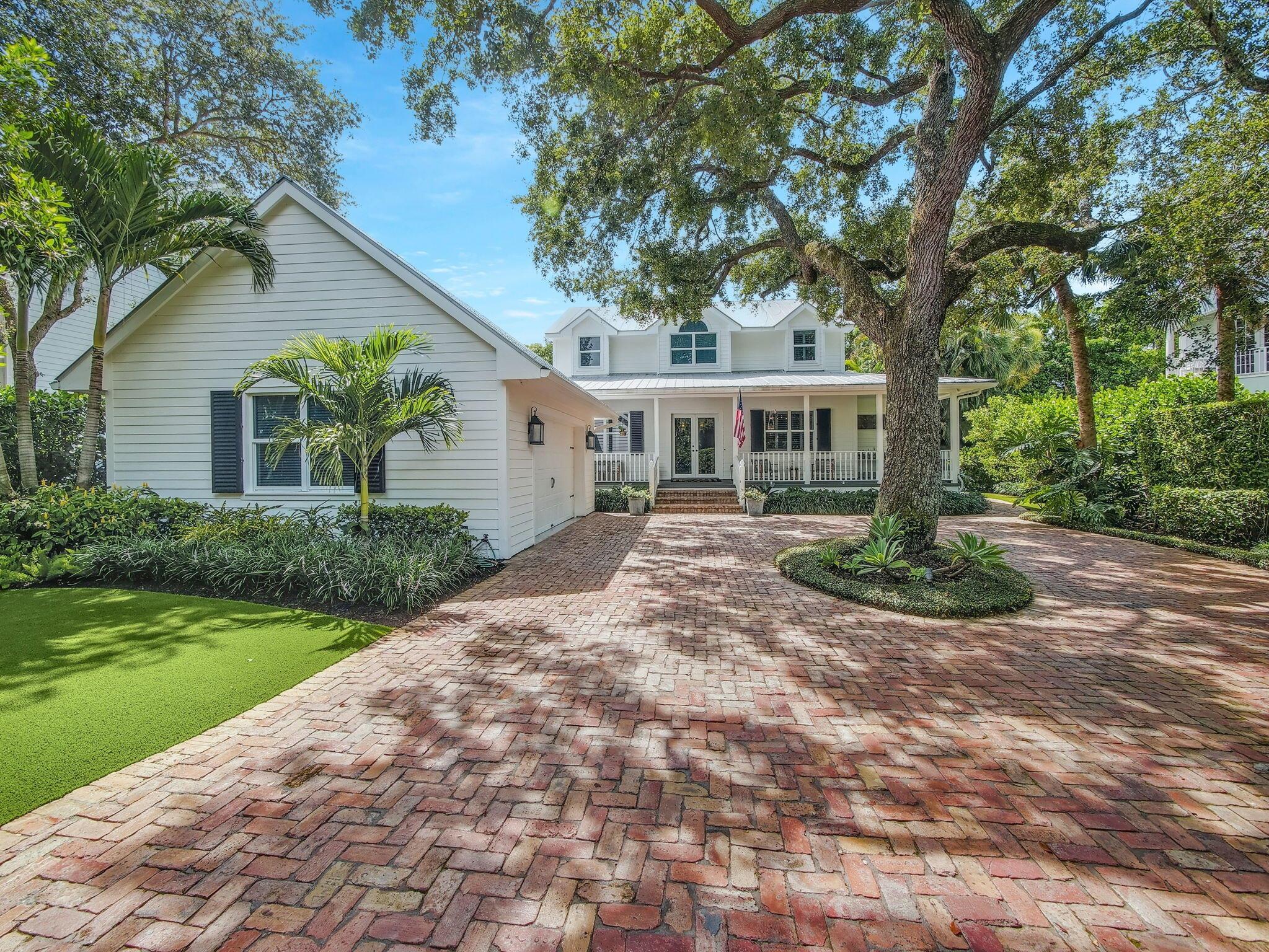 Nestled in the 17 residence secluded Natures Hideaway neighborhood in Palm Beach Gardens, this custom built & meticulously maintained 4BR/3BA + den, loft, pool & detached 2-car garage CBS home is turn-key & ready for its new owner. Majestic 100-year-old oak trees and palms line the quiet one-way street that welcomes you as you enter the communities' gates. Situated on a roughly 1/2 acre lot, the long Chicago brick paver driveway and pristine landscaping lead you to the relaxing front porch. Once through the double-entry French doors a pretty fireplace & sitting area greet you. The open kitchen is a chef's paradise with plenty of counterspace, storage & center island ideal for food prep & conversation. The stainless steel appliances include a gas stovetop for optimal cooking. The luxurious