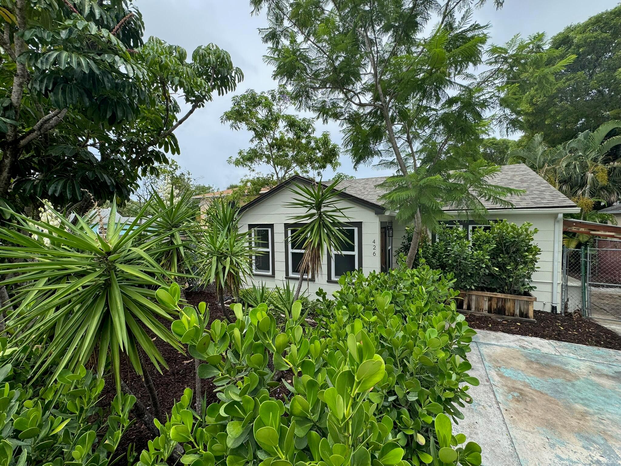 Beautifully Updated Home with Detached Studio Apartment walking distance to Lake Worth Beach Shops, Restaurants, Bars and just 1.5 miles to the Beach! Main House is 3 bedrooms/2.5 Bathrooms. The Studio Apartment has a Full Kitchen and Full Bathroom with its own gated driveway, Ideal for Guests, In-Laws, or Potential Rental Income. All Big Expenses are Completed with a 2025 Roof, IMPACT Windows, AC, & Water Heater. Both the Main House and Studio Apartment Feature Top-to-Bottom Upgrades, Including NEW flooring, FULLY Renovated Bathrooms, NEW Lighting, & NEW Kitchens with Quartz Countertops & NEW Appliances. FRESHLY Painted Inside & Out, with a Newly Designed Landscape Creating a Nature-Inspired Paradise. The Home also Features a Fully Fenced Yard, Separate Driveway Entrance from the Front
