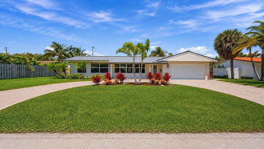 Nestled in the highly desirable Venetian Isles Third Section of Lighthouse Point, within the coveted "Panhandle" area known for its quiet, low-traffic streets and exceptional location, this beautifully maintained 3-bedroom, 2-bathroom pool home perfectly combines major modern upgrades with the timeless charm of South Florida living. Offering 1,850 square feet under air and 2,173 total square feet, a full 2-car garage, and an ideal split-bedroom floor plan, this residence has been thoughtfully updated throughout with quality improvements designed for both comfort and peace of mind. One of the home's standout features is its light filled east facing exposure, enhanced by expansive full hurricane impact windows and doors throughout the entire property, including an impact rated garage door. Natural sunlight pours into the interior from nearly every angle, creating a bright and inviting atmosphere while seamlessly connecting the indoor and outdoor living spaces. Major recent upgrades include a premium 2023 aluminum metal roof, ideally suited for South Florida's coastal environment, and a brand new 2024 air conditioning system with built in air scrubbers, both covered by transferable warranties that provide the future owner with outstanding long term value, added protection, and exceptional peace of mind, along with newly remodeled bathrooms, a beautifully updated kitchen with all new appliances, newer washer and dryer, rebuilt pool pump, fresh interior and exterior paint, and recent landscaping improvements, all completed within the past two years.  From the moment you arrive, the expansive semi-circle brick driveway and lush tropical landscaping create exceptional curb appeal. Inside, the spacious living and dining areas are designed for both everyday living and entertaining, featuring a unique curved brick accent wall that adds warmth, architectural character, and timeless charm to the light-filled interior. Expansive impact sliding glass doors open from multiple rooms throughout the home to the patio and pool area, creating abundant natural light and effortless indoor-outdoor flow. The fully remodeled kitchen serves as the centerpiece of the property, showcasing modern finishes, abundant natural light, and an open flow into the primary living spaces.     Designed with both comfort and privacy in mind, the split-bedroom floor plan places the secluded primary suite on its own private wing of the home, thoughtfully separated from the additional bedrooms. The spacious primary retreat features expansive impact sliding glass doors that open directly to the pool and patio area, creating a bright, airy atmosphere and seamless indoor-outdoor living. Grand double-door entry access enhances the sense of space and privacy within the suite, while the oversized walk-in closet provides abundant storage and organization space. The beautifully remodeled primary bathroom also offers direct exterior access to the pool area, an incredibly convenient feature for entertaining and everyday Florida living, allowing guests or owners to step inside from the pool without having to walk through the rest of the home. Newer flooring in the bedrooms complements the tile flooring throughout the main living areas and kitchen, creating a clean and cohesive feel throughout the residence.     Step outside into your own private tropical oasis. The large fenced backyard is perfectly designed for the South Florida lifestyle, featuring a sparkling in-ground pool, expansive patio areas, and a built-in outdoor bar ideal for entertaining, relaxing, and hosting gatherings year-round. The seamless indoor-outdoor flow and abundance of natural light make every part of the home feel connected to this private backyard retreat.     Located just moments from the community recreation center, beaches, marinas, dining, and the prestigious yacht club, this home offers an incredible opportunity to enjoy one of the most sought-after neighborhoods in Lighthouse Point. Combining premier location, extensive upgrades, hurricane protection throughout, and a bright open layout designed for Florida living, this is truly a special place to call home.