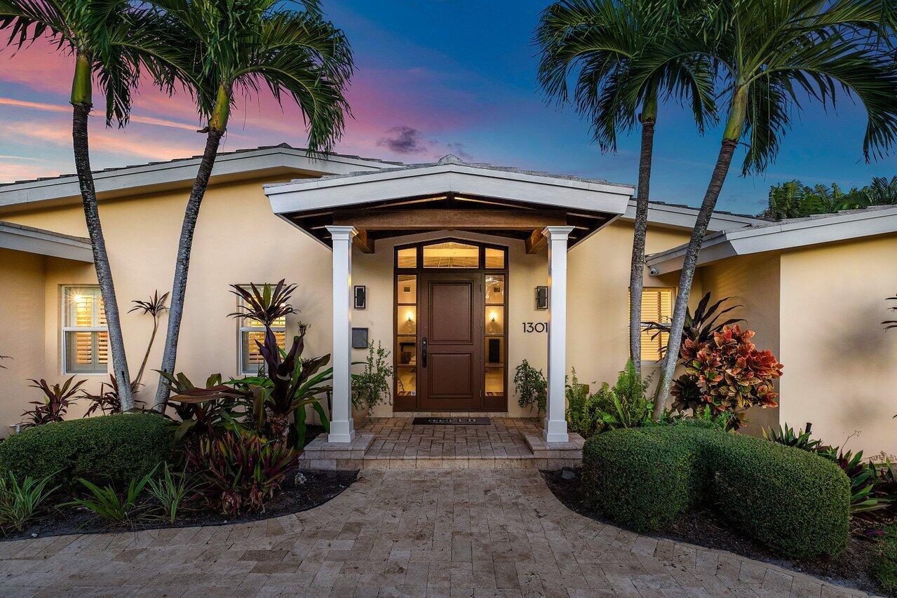 California Cool in Lake Ida - A Coastal Chic RetreatEffortlessly blending laid-back California charm with South Florida's tropical allure, this stunning Lake Ida residence is the epitome of style, comfort, and location. Less than a mile from Downtown Delray Beach and just minutes from the Atlantic Ocean, this custom-renovated, single-story home sits on an oversized, lushly landscaped lot in one of the area's most sought-after neighborhoods.From the moment you enter, you're greeted by soaring vaulted wood-beamed ceilings and beautifully refinished hardwood floors, setting the tone for the home's inviting warmth and refined quality. Expansive windows and impact glass doors bathe the interiors in natural light, creating a seamless connection to the outdoors while enhancing the home's