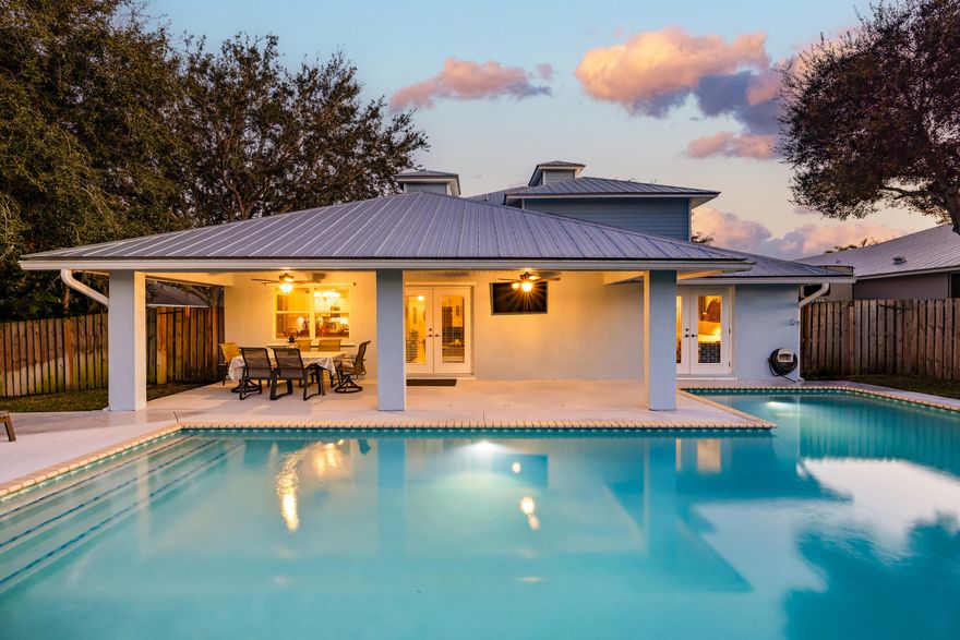 Located in the desirable Zeus Park community, this well-maintained CBS home offers over 3,300 total square feet with 4 bedrooms and 3.5 baths. Volume ceilings and real hardwood oak flooring create a bright, inviting atmosphere throughout the main living areas. The open kitchen features quartz countertops and is ideally positioned between the family room and formal dining room, overlooking the resurfaced 28,000-gallon pool, perfect for entertaining. A brand-new driveway and fenced yard enhance both curb appeal and privacy. The primary suite is located on the main level and offers private pool access along with a spacious en-suite bath featuring a soaking tub and separate shower. Upstairs, an oak staircase leads to two guest bedrooms with a shared bath, plus an additional en-suite bedroom with a walk-in closet. New carpet is being installed upstairs. A 2021 metal roof adds peace of mind. Conveniently located just 1.5 miles to the beach and less than half a mile to shopping and dining.