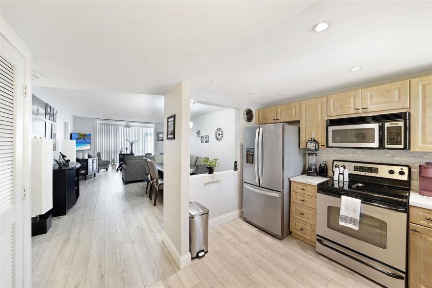 Beautifully remodeled 2-bedroom, 2-bath unit on the 1st floor. The extended living area and Florida room feature hurricane impact windows and doors, including a back door that serves as an emergency exit and opens to a serene lake view. The spacious master bedroom includes a walk-in closet, with laminate flooring throughout the unit. The renovated kitchen features recessed lighting and stainless steel GE appliances (range, microwave, dishwasher from 2012), complemented by a new Whirlpool refrigerator (2024). A/C and W/H are Rheem models from 2016. This is an active 55+ community, the complex boasts its own golf course with free access for residents. The clubhouse offers a wide range of amenities including tennis courts, indoor and outdoor heated pools, sauna, and gym.