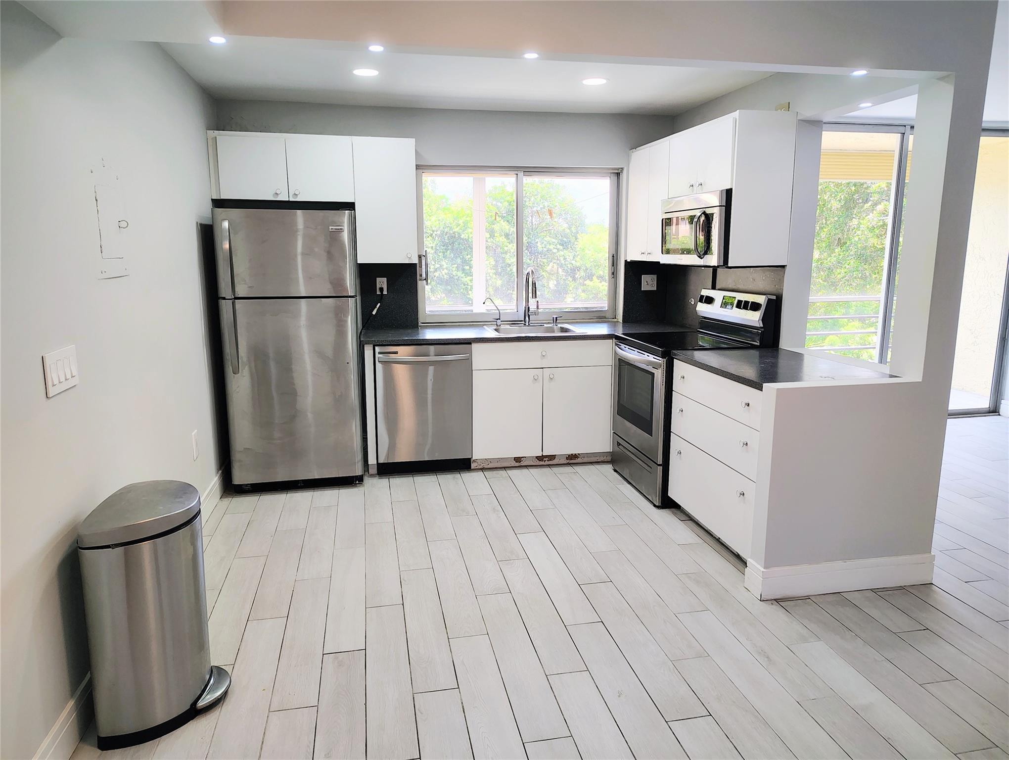 Beautifully UPDATED corner unit in a desirable 55+ community offering a bright and spacious split floorplan. This home features REMODELED floors throughout, an updated OPEN kitchen with modern finishes, and contemporary fans in every bedroom. Enjoy serene ample LAKE VIEWS with a partial golf course backdrop, creating the perfect setting for relaxation. The building is well maintained with a newer roof, and there are NO special assessments, providing peace of mind for buyers. Steps away from elevator and laundry room. Cable and internet included in maintenance fee. 40 yr inspection passed. A wonderful opportunity to own a move-in ready residence in a welcoming community.