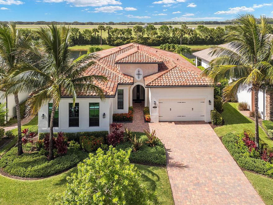 Step into unparalleled luxury in this stunning single-story estate nestled within the exclusive guard-gated Palm Meadows Estates. Your 4-bedroom, 3.5-bathroom Cheshire model boasts over 3,080 square feet of meticulously designed living space, blending timeless elegance with modern sophistication in an open-concept layout with dramatic volume tray ceilings and sleek lines throughout, creating a bright and airy ambiance perfect for both grand entertaining and serene relaxation. Gourmet chef's kitchen, the heart of the home, showcases a massive designer island, top-tier stainless steel appliances, custom cabinetry seamlessly connect to an expansive great room & elegant dining area.Your lavish primary suite is a private oasis, offering tranquil water views a dual walk-in closets!