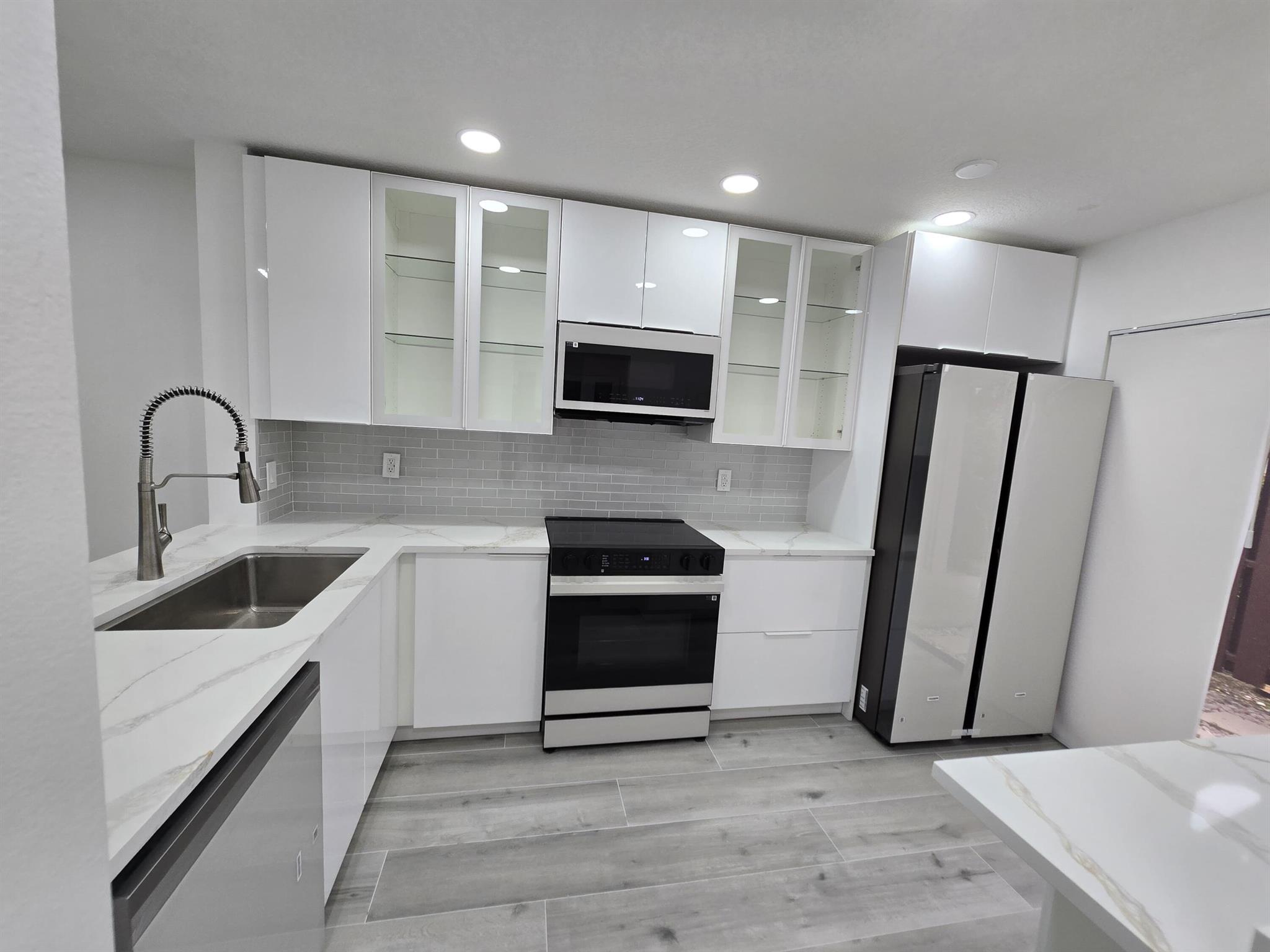 Fully remodeled 2 bedroom, 2.5 bathroom pond view townhouse in The Township, Coconut Creek, featuring modern upgrades throughout including luxury flooring, recessed lighting, and an open living and dining area. The brand new kitchen offers sleek white cabinetry, quartz countertops, glass-front cabinets, subway tile backsplash, and new appliances, perfect for everyday cooking and entertaining. Both bathrooms are updated with stylish finishes, and the bright open layout creates a spacious, move-in ready home. The Township enjoy resort-style amenities including pool,clubhouse, fitness center, tennis, basketball, racquetball, and walking trails, all  just minutes from shopping, dining, highways, and top schools. This Coconut Creek Townhouse combines modern design, a serene pond view,