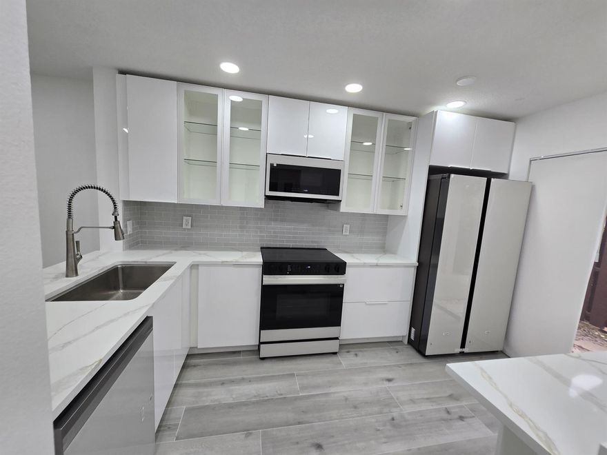 Fully remodeled 2 bedroom, 2.5 bathroom pond view townhouse in The Township, Coconut Creek, featuring modern upgrades throughout including luxury flooring, recessed lighting, and an open living and dining area. The brand new kitchen offers sleek white cabinetry, quartz countertops, glass-front cabinets, subway tile backsplash, and new appliances, perfect for everyday cooking and entertaining. Both bathrooms are updated with stylish finishes, and the bright open layout creates a spacious, move-in ready home. The Township enjoy resort-style amenities including pool,clubhouse, fitness center, tennis, basketball, racquetball, and walking trails, all  just minutes from shopping, dining, highways, and top schools. This Coconut Creek Townhouse combines modern design, a serene pond view,