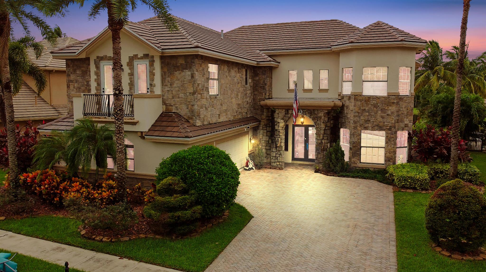 Prepare to be enchanted by this truly magnificent waterfront estate, perfectly nestled in a desirable, lake-front community in Wellington. The home immediately impresses with its grand, European-inspired architecture, featuring a new roof, new impact windows & doors, an elegant stone and stucco facade, permanent whole house generator and a sweeping paver driveway leading to the attached garage. The meticulously manicured tropical landscaping and towering palm trees frame the residence, setting a tone of upscale elegance before you even step inside.