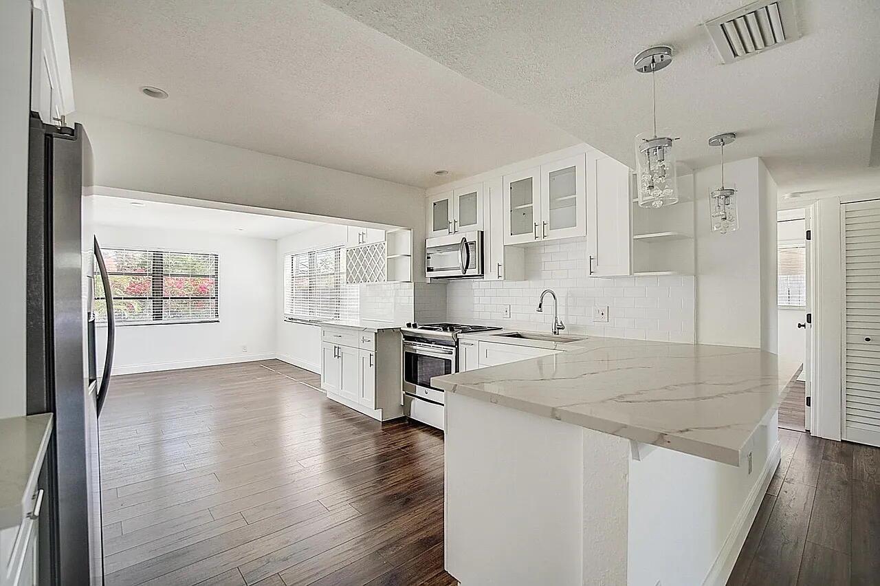 This exceptional and meticulously maintained property is located in the heart of Lantana, just a short walk from both the beach and the Intracoastal Waterway. The bright and spacious floor plan creates a welcoming atmosphere for family living. The thoughtfully designed split-bedroom layout ensures privacy for the master suite, while the bathrooms are elegantly appointed to suit the most discerning tastes. The open, functional kitchen fosters both inclusivity and efficiency, ideal for everyday living. Modern, stainless appliances with an accompanying built in wine rack compliments the space. The fully fenced backyard is perfect for outdoor gatherings and entertaining. Ample parking is available, and the neighborhood offers a wonderful and welcoming community atmosphere.