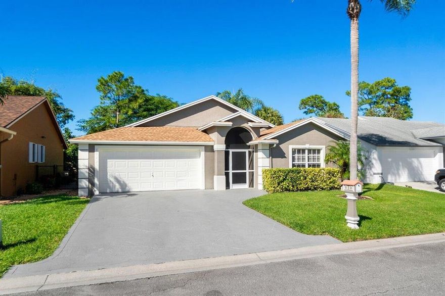 Offering three bedrooms, two full baths and a two-car garage, this gem is just waiting for new owners to move in and start making memories. Ideally located, this gorgeous home sits in a sought after gated community with a very low HOA of only $53 per month. As you approach, a screened front entry and pristine landscaping provide a warm welcome. Inside, grey wood look laminate flooring (installed 2016), stylish fixtures, lofty vaulted ceilings and large windows create an ambiance of elegance and charm. The spacious kitchen is ideal for both daily meal prep and entertaining. Enjoy new stainless-steel appliances (2019), solid wood cabinets with generous storage and upgraded hardware, plus a large island with bar style seating. Gather for dinner in the adjoining (SEE SUPPLEMENT) dining area then unwind in the comfortable living room beyond. Sliding doors lead out to a wonderful back patio and private, fully fenced yard with no rear neighborsperfect for children to play and pets to roam. Sleep soundly in the tranquil master bedroom with engineered wood flooring (2016) and sliding doors offering direct yard access. The attractive ensuite bath was newly updated in 2021 and boasts beautiful ceramic tile throughout, a new double vanity and a freestanding tub with rain head shower. Brand new outlets have two overhead light settings, including a nightlight setting, plus LED lights in the shower niche combine to create an overall relaxed and luxurious feel. The spacious and comfortable secondary bedrooms have ample closet space and are configured in a Jack-and-Jill setup. The secondary bath includes a vanity, linen closet, and tub/shower enclosure. A dedicated laundry room with new washer and dryer (2019) help keep mess out of sight. A security alarm, underground Xfinity cable ran for Wi-Fi and DIRECTV set up, as well as a custom mailbox provide safety, charm, and convenience. All appliances are gas resulting in reduced utility costs and a complete set of hurricane protection panels with hardware are included. Additional desirable features: a new roof was installed in (2018), the home's exterior was painted in (2016), and new AC was installed in (10/2014). Residents of this fabulous community enjoy great amenities including a basketball court and large grassy field for activities. Perfectly situated just a few minutes away from the turnpike, Okeeheelee park which has a water park and dog park, and schools, shopping, dining, and entertainment. This will not last. Schedule your showing today!