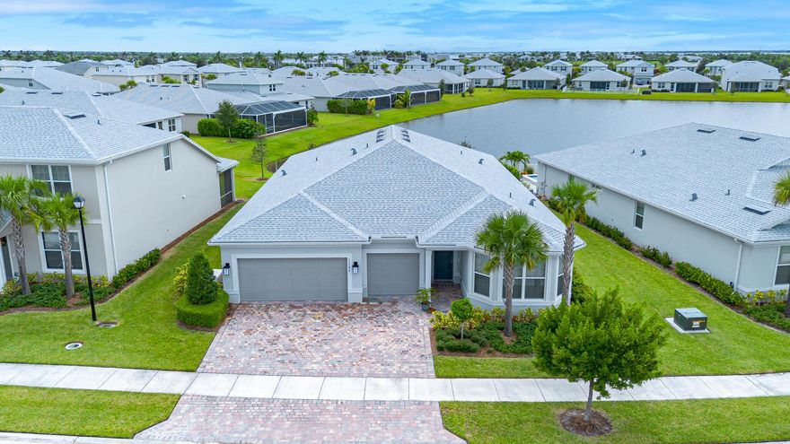 NEW TO MARKET! Stunning 3 bedroom + den, 3 bath home with 3-car garage in the sought-after gated community of Heron Preserve at Tradition. Enjoy serene lake views from the full-view screened lanai. This home features stylish wood look tile flooring throughout, impact windows & doors, pocketing sliders that disappear when opened and a gourmet kitchen with high end KitchenAid appliances, oversized walk-in pantry, and elegant design elements. Neutral tones and high-end finishes. The primary suite offers custom closet systems for exceptional storage and style. The versatile den has double doors for privacy, while the custom built drop zone by the laundry adds excellent storage. The upscale window treatments complete the polished look.